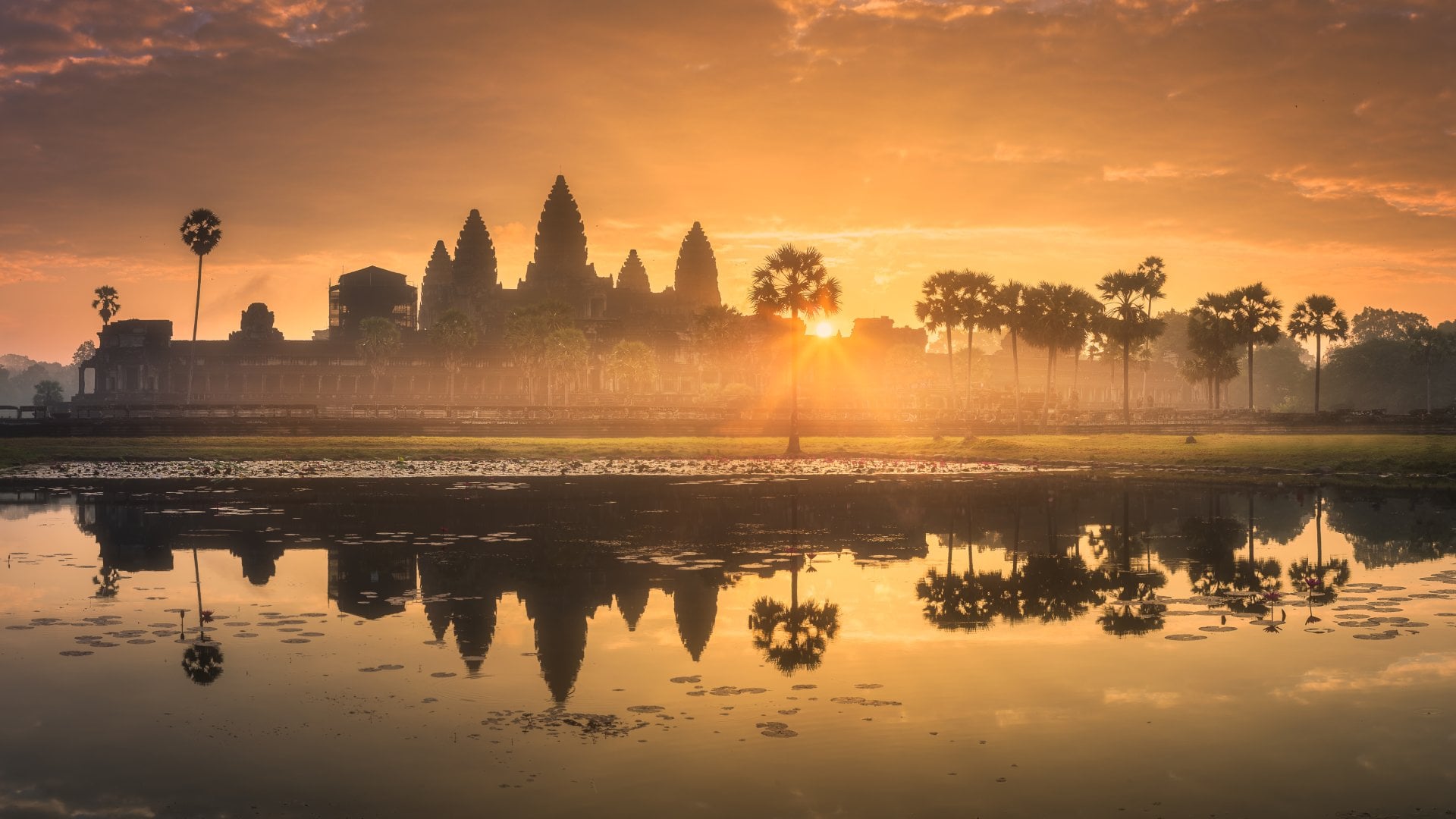Angkor Wat, Cambodia sunrise over a temple with water reflecting in foreground