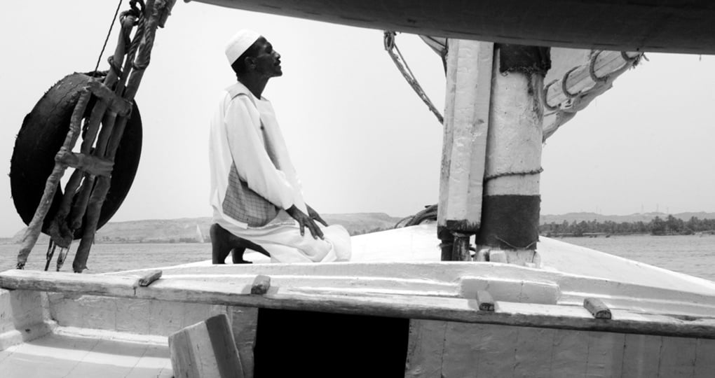 A muslim man prays on a Felucca