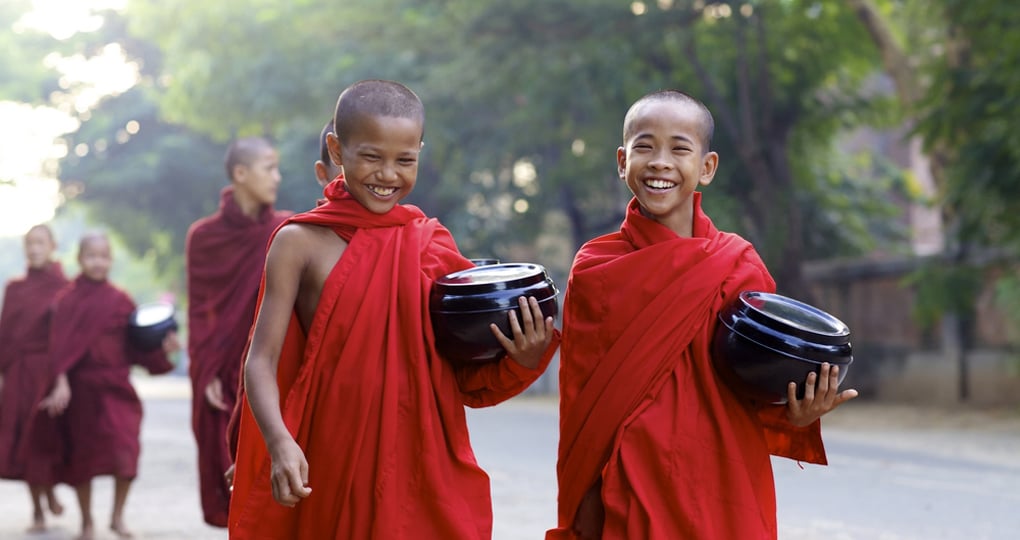 Young Buddhist monks smiling on their morning alms walk Young Buddhist monks smiling on their morning alms walk