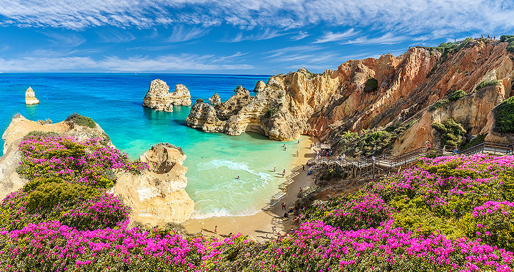 Experience the ultimate beach experience at Praia do Camilo, a sandy cove with picturesque blue waters