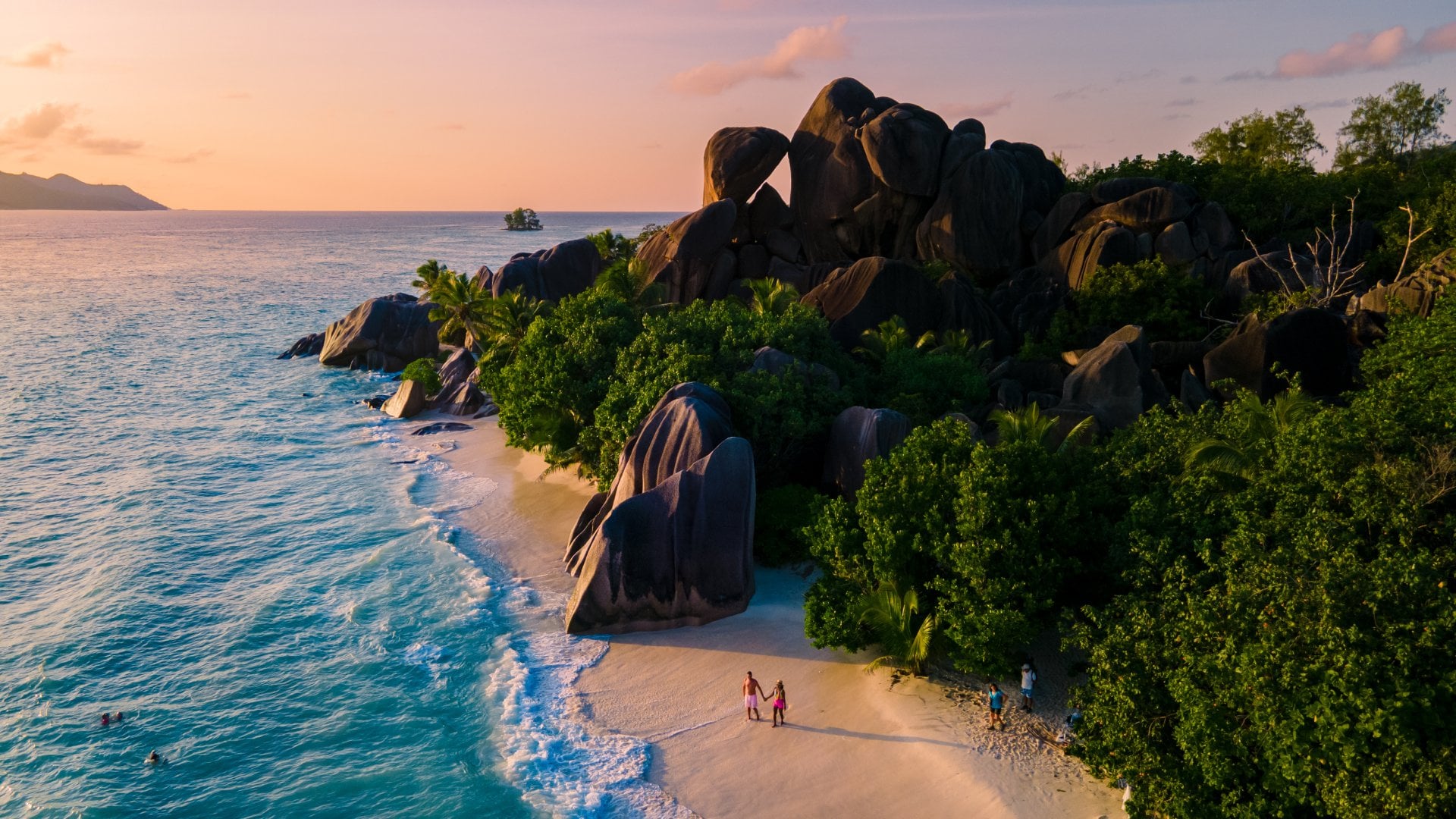 Anse Source d'Argent, La Digue Seychelles, young couple men and woman on a tropical beach during a luxury vacation in the Seychelles. 
