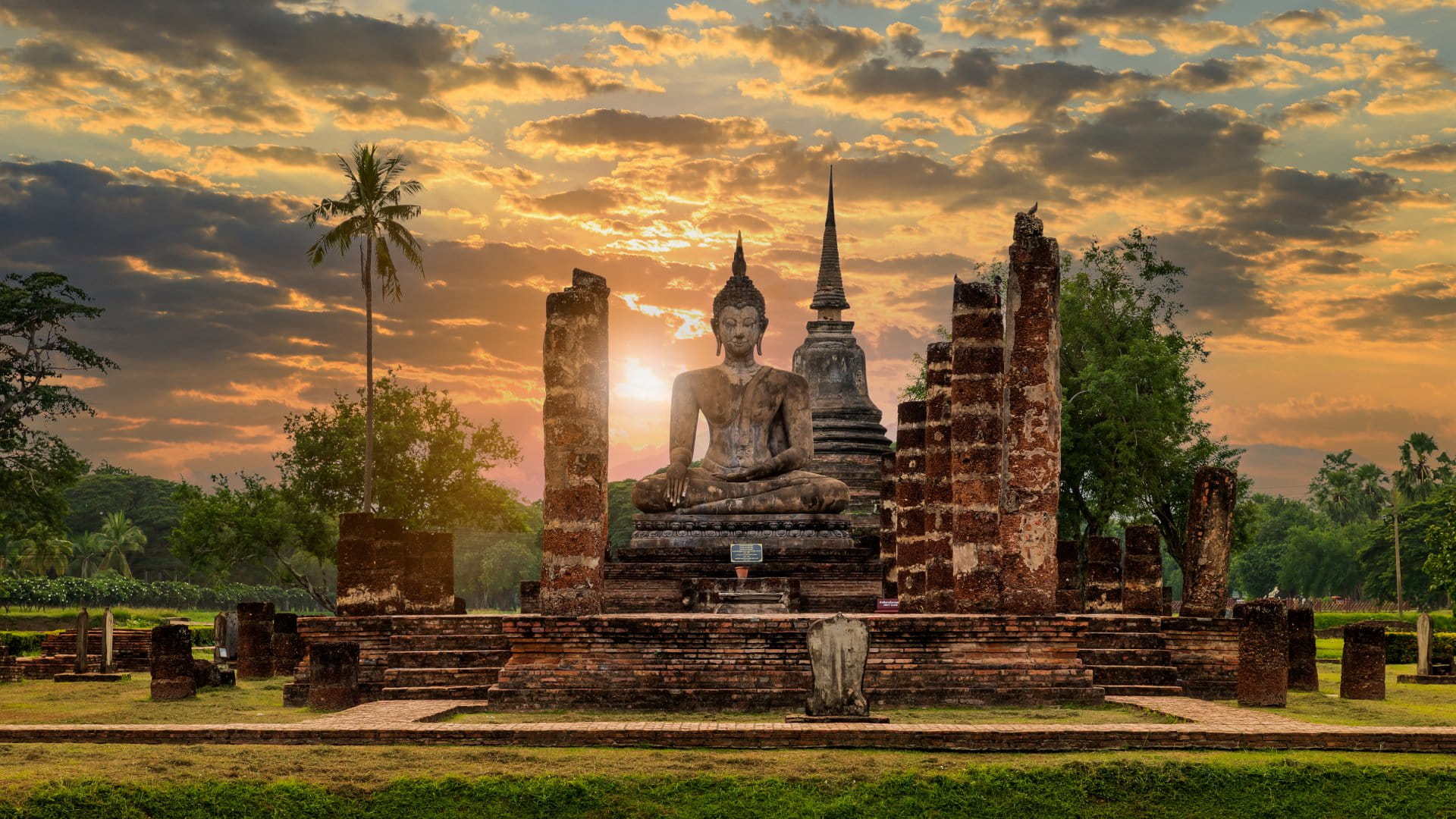 Buddha statue and pagoda Wat Mahathat temple with dramatic syk
