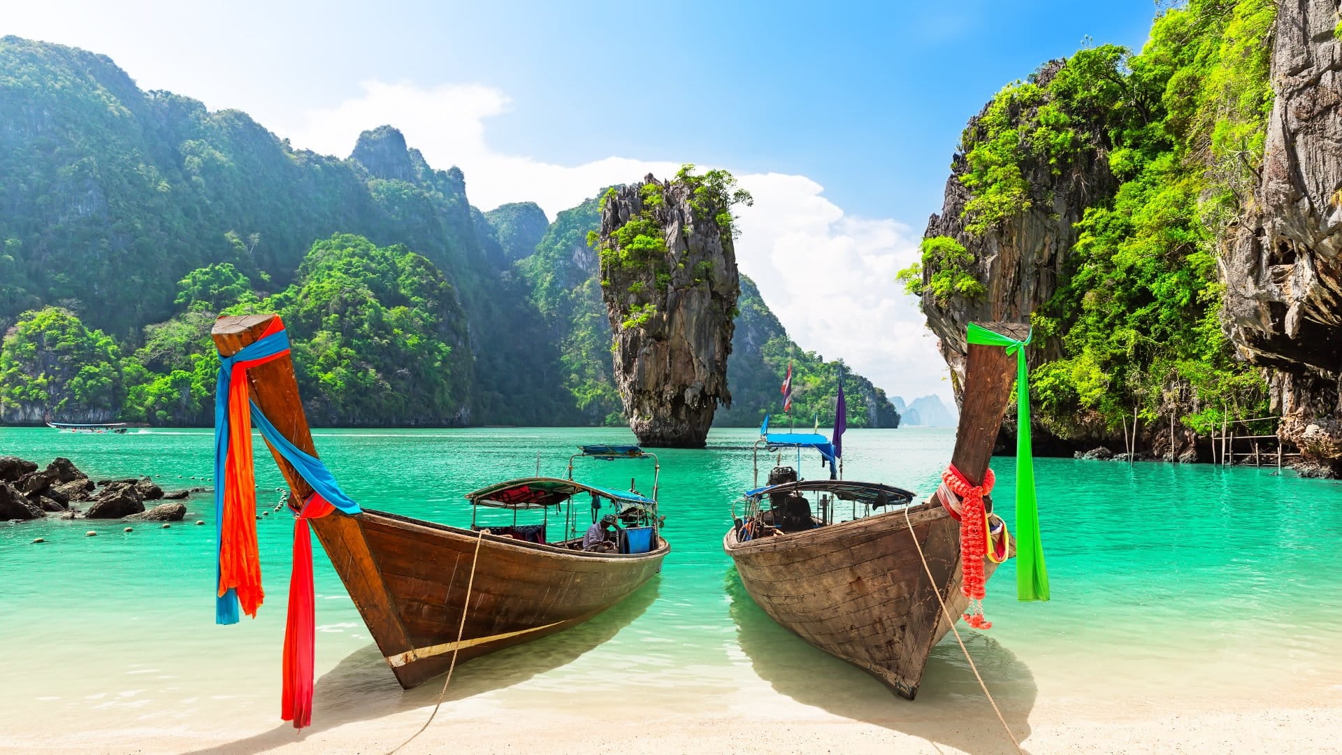 James Bond island with thai traditional wooden longtail boat and beautiful sand beach in Phang Nga bay, Thailand