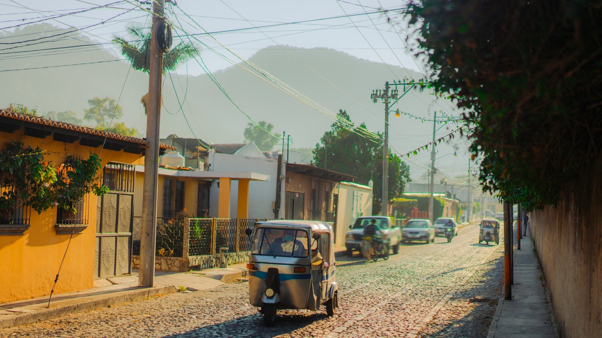 Guatemala Tuk-tuk three wheeled vehicle driving along historical street in Guatemala