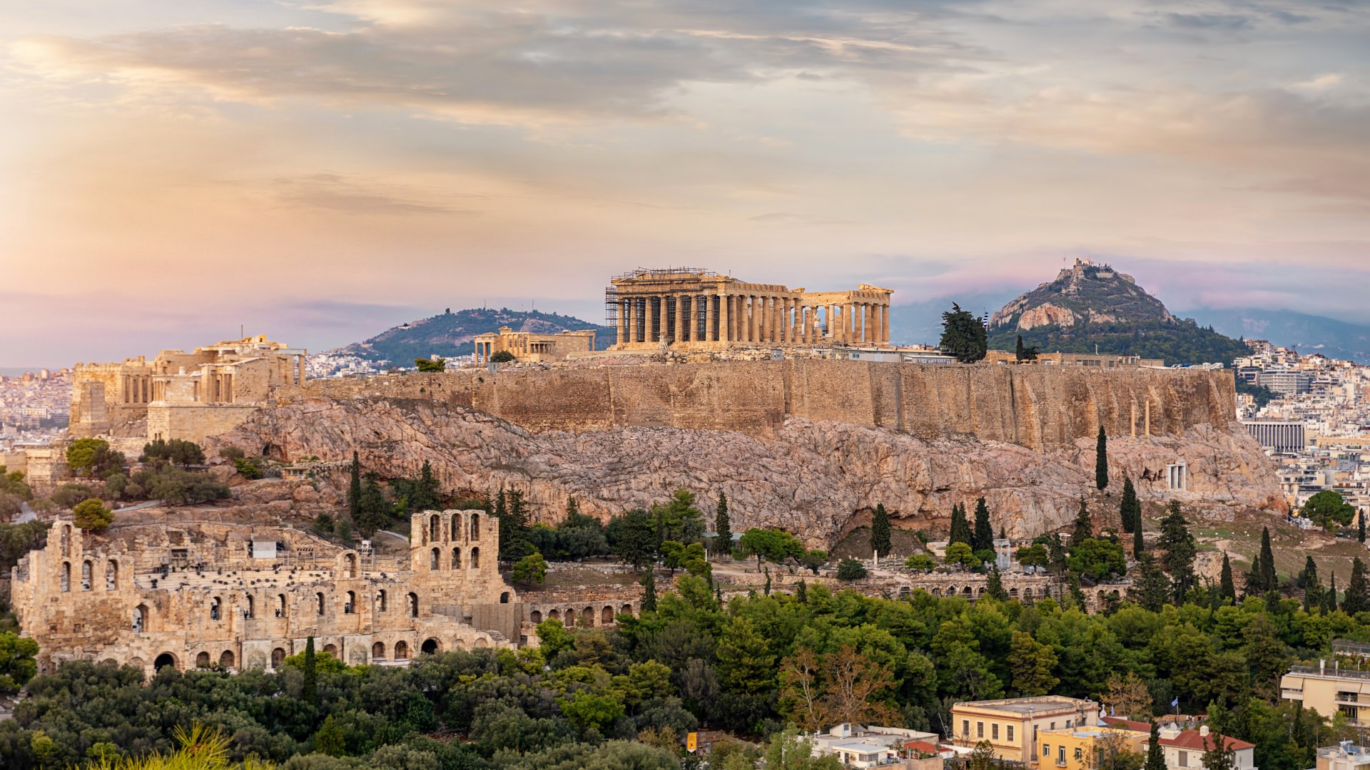 View to the Acropolis of Athens on top of the old town Plaka during a cloudy summer sunset, Greece