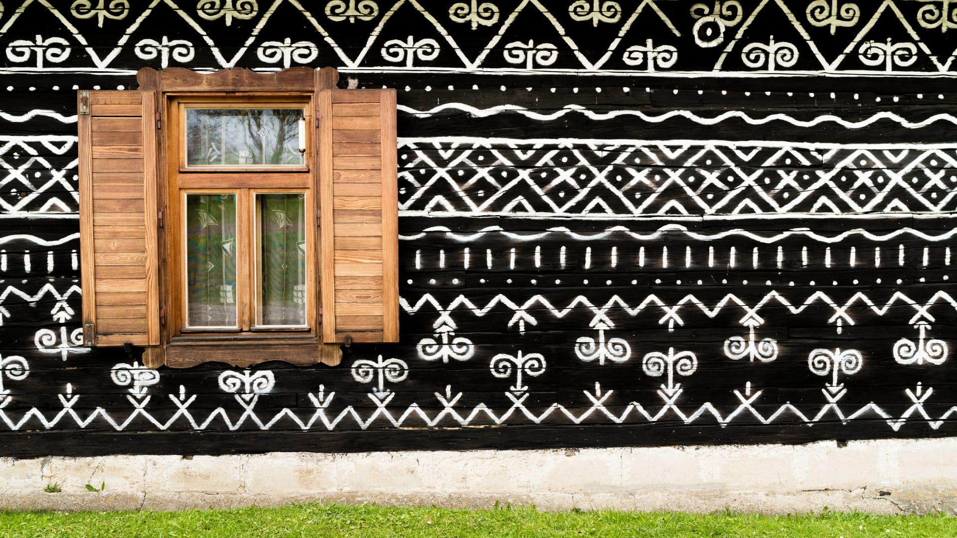Wooden window on the White and black pattern ornament painting on the dark wood wall in Slovakian old village Cicmany