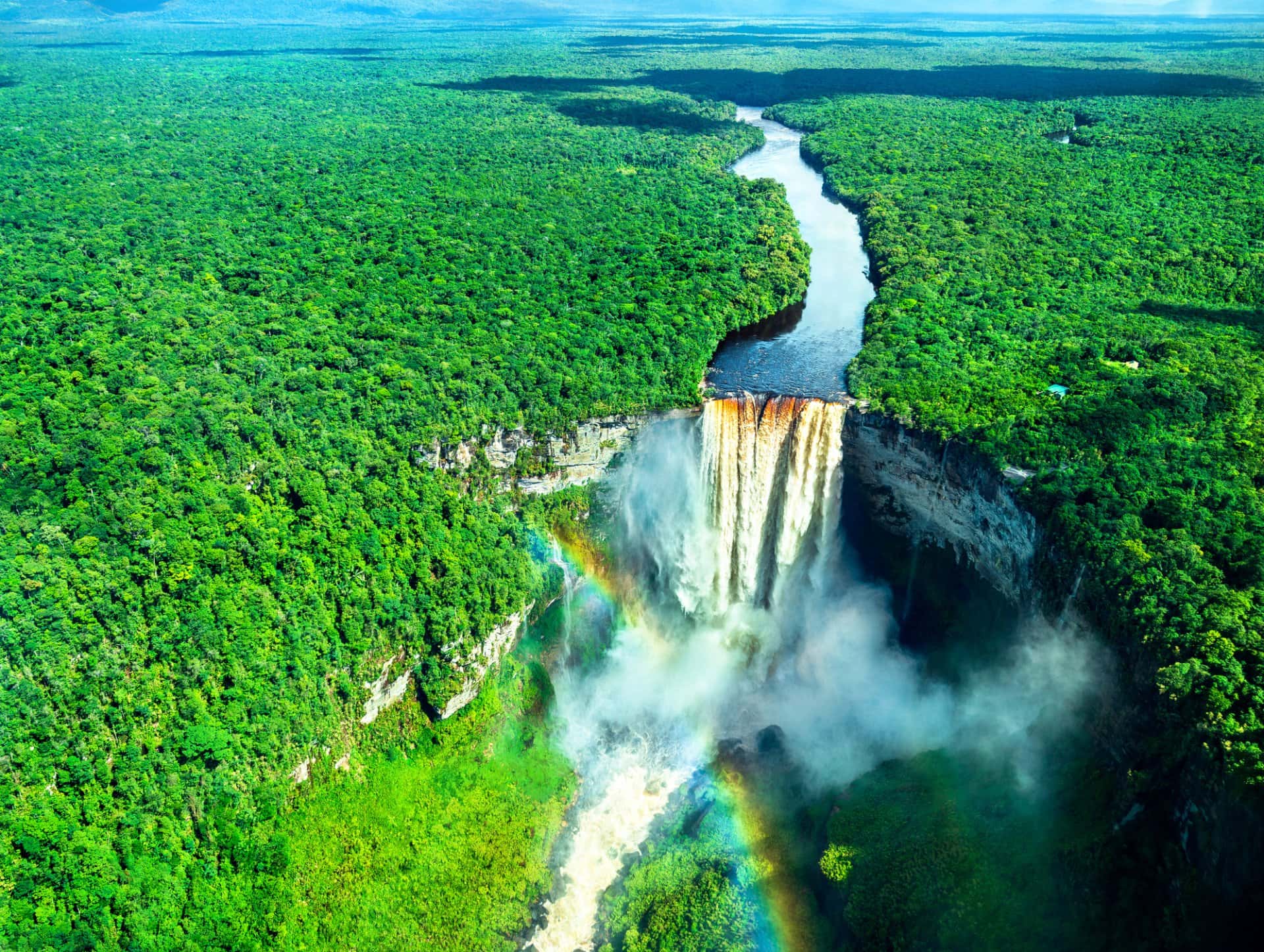 Aerial view of Kaieteur Falls with a rainbow in a rainforest in Guyan