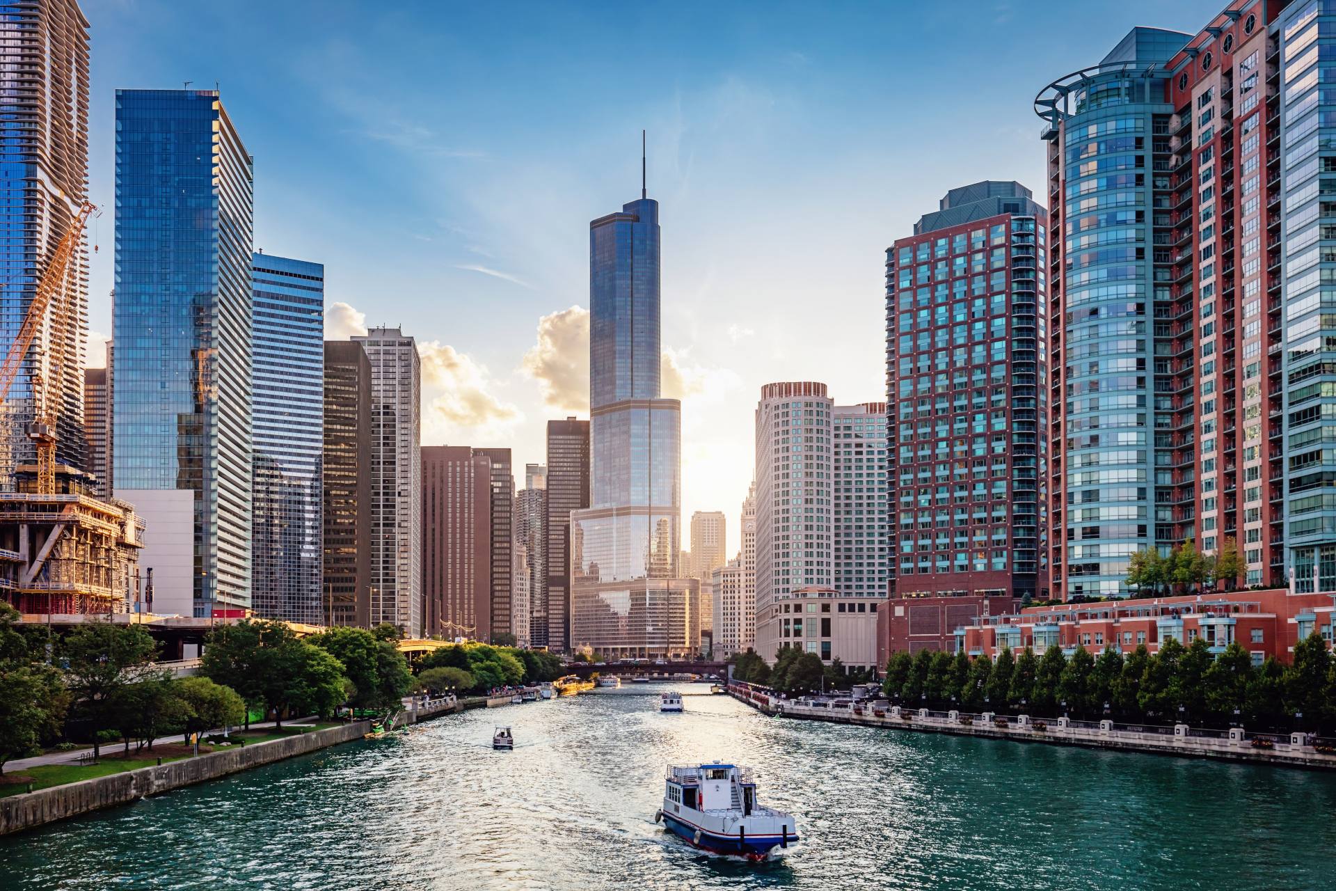 Cityscape from Chicago River Waterfront at Dusk. Small boats and tourist ferries cruising towards the Michigan Lake