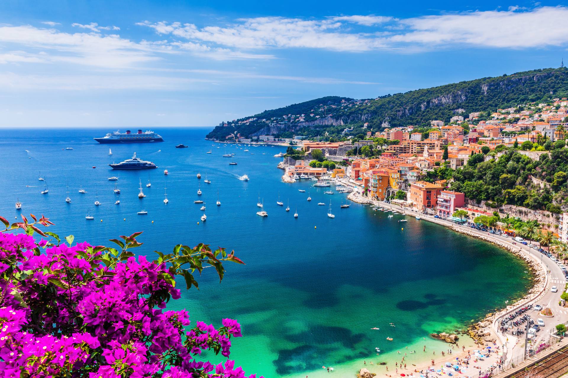 Aerial view of the vibrant town and beach with boats in the water