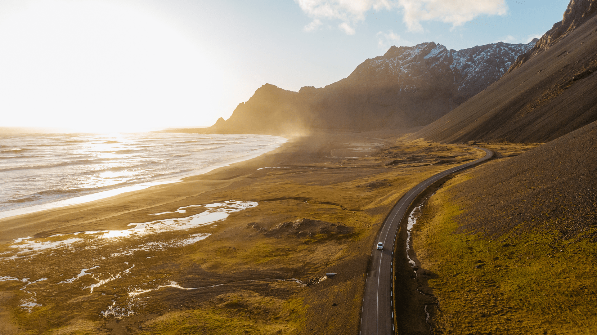 Uncover the magic of Iceland on your next road trip. Aerial view of a car driving on scenic road in Iceland