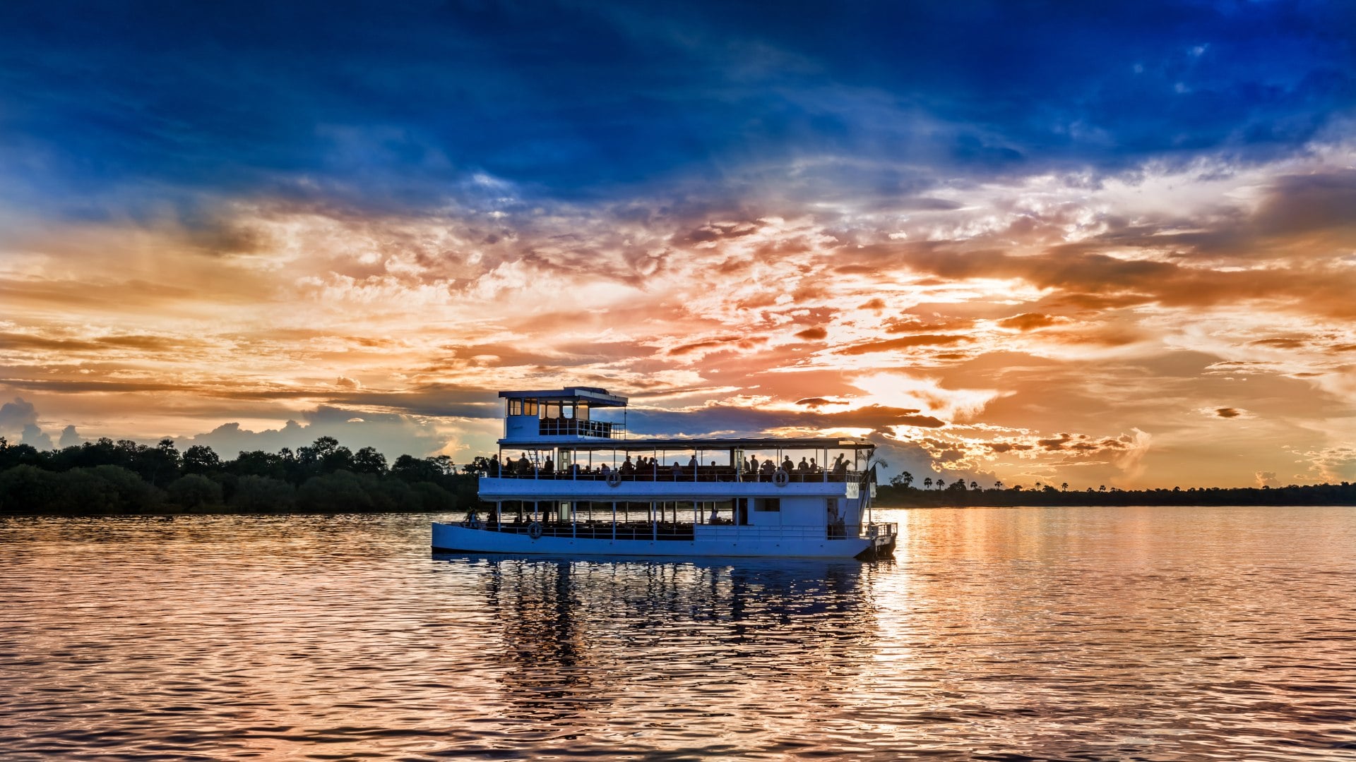 Picturesque sunset landscape with the riverboat at Zambezi river