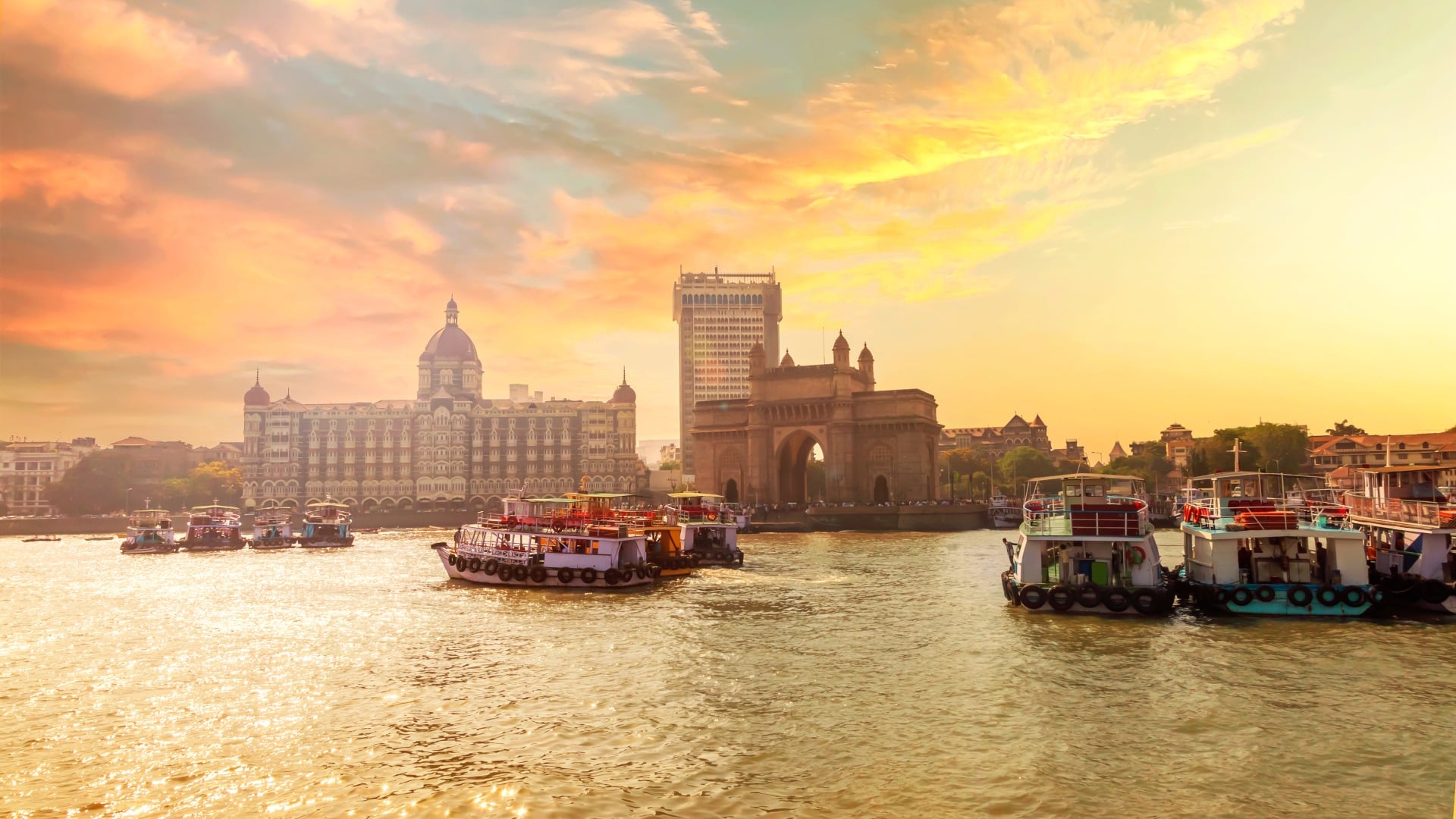 Mumbai Harbor with beautiful warmly lit sky, Gate of India along with Taj and keeping the boats in the foreground