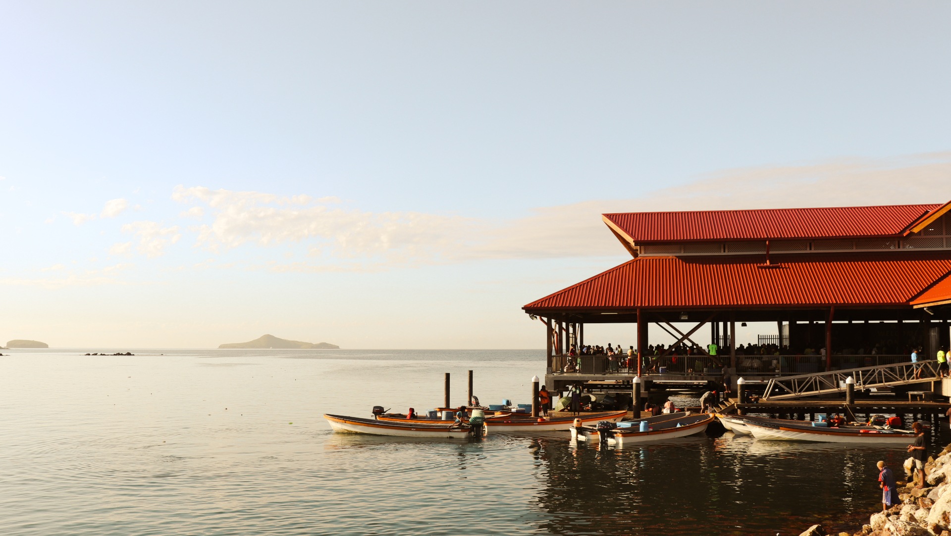 Boats on dock beside oceanside Papua New Guinea market