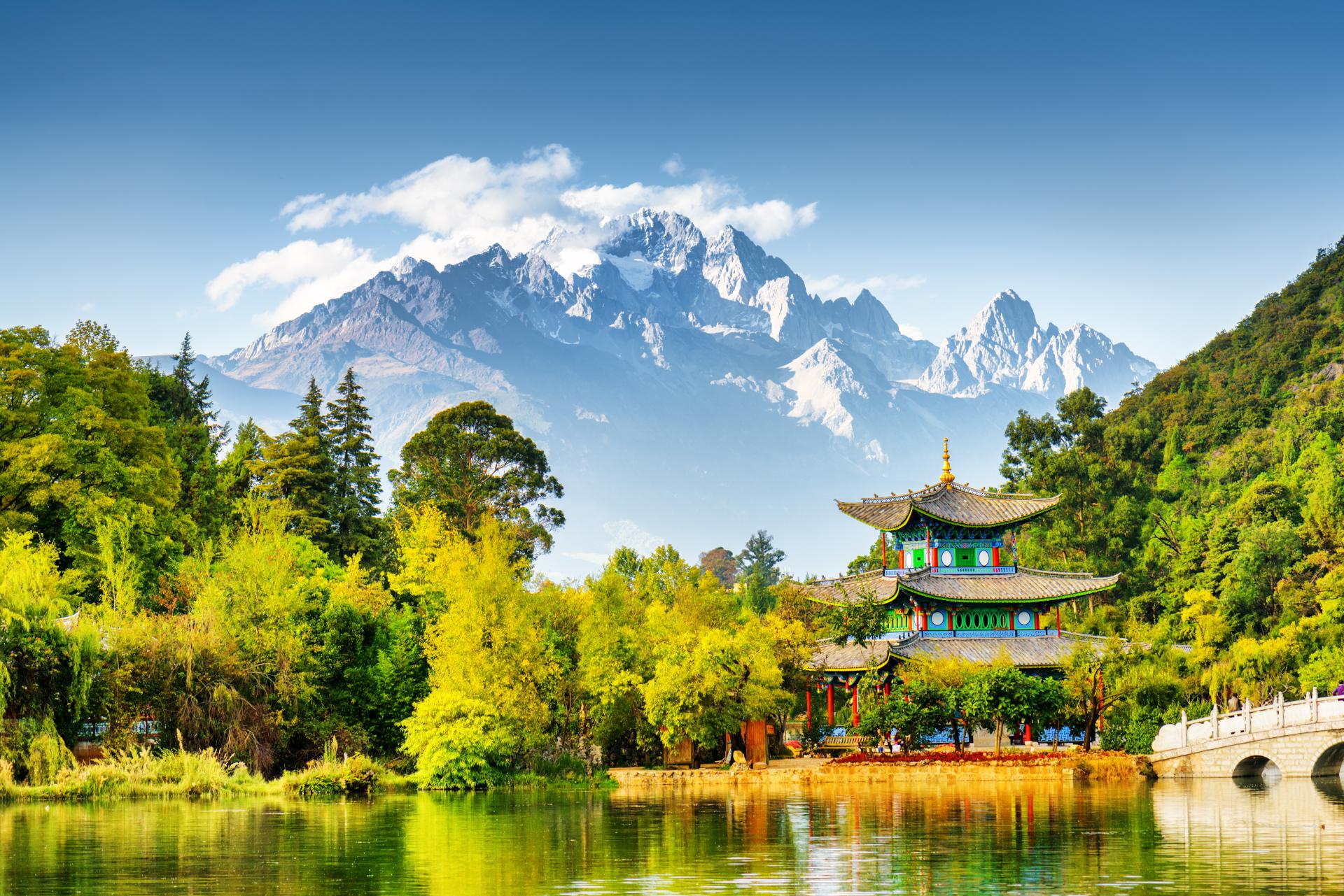 Scenic view of the Jade Dragon Snow Mountain and the Moon Embracing Pavilion on the Black Dragon Pool in the Jade Spring Park, Lijiang, Yunnan province, China.