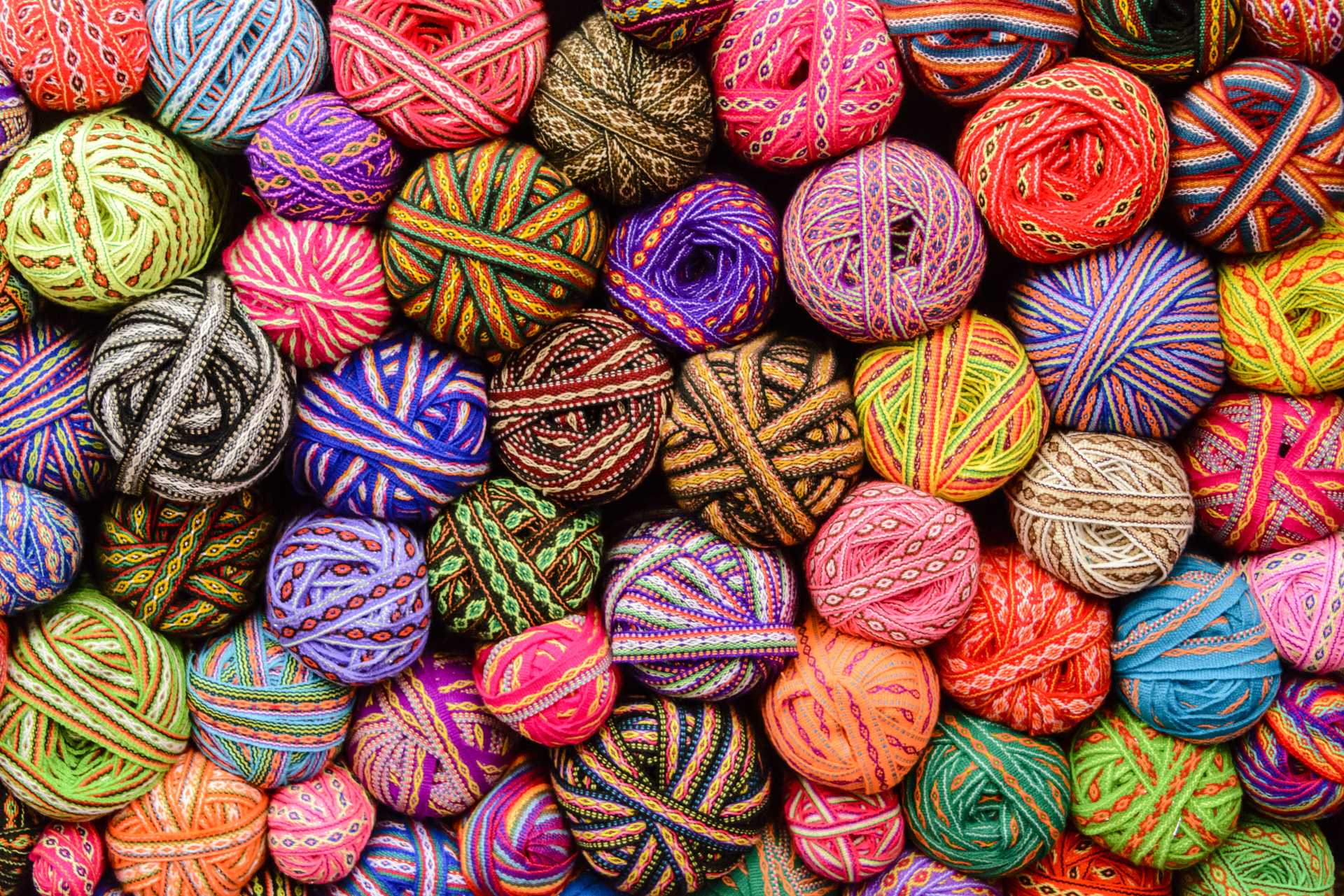 Textiles in Cusco, Peru A large variety of colorful traditonal balls ribbons in market in Cusco, Peru