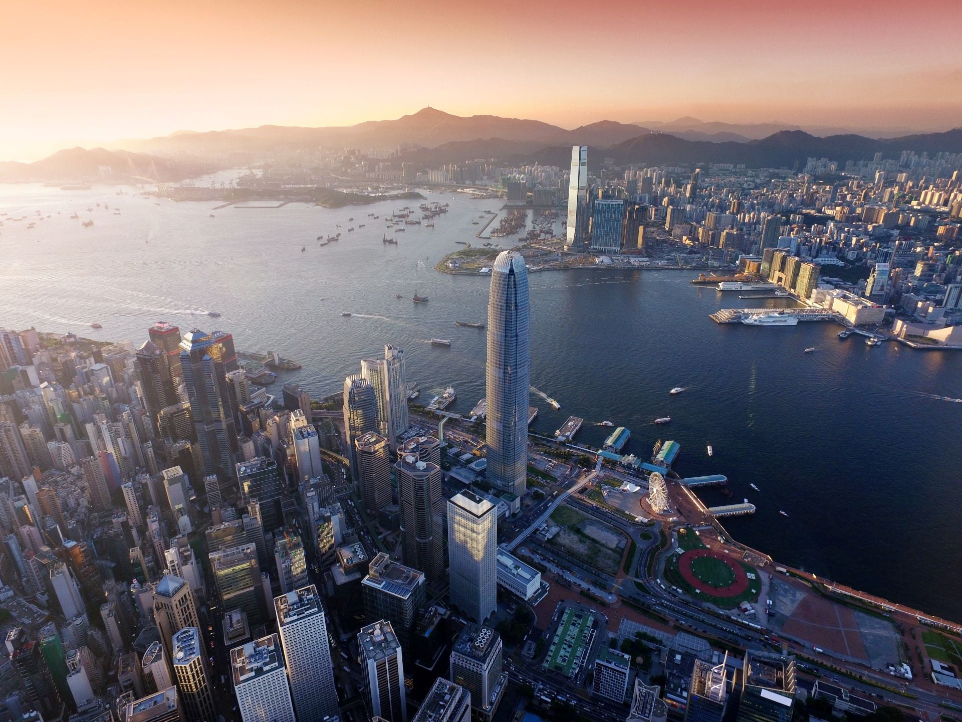 Dramatic skyline of Hong Kong Island and busy ships navigates across the Victoria Harbour during beautiful sunset