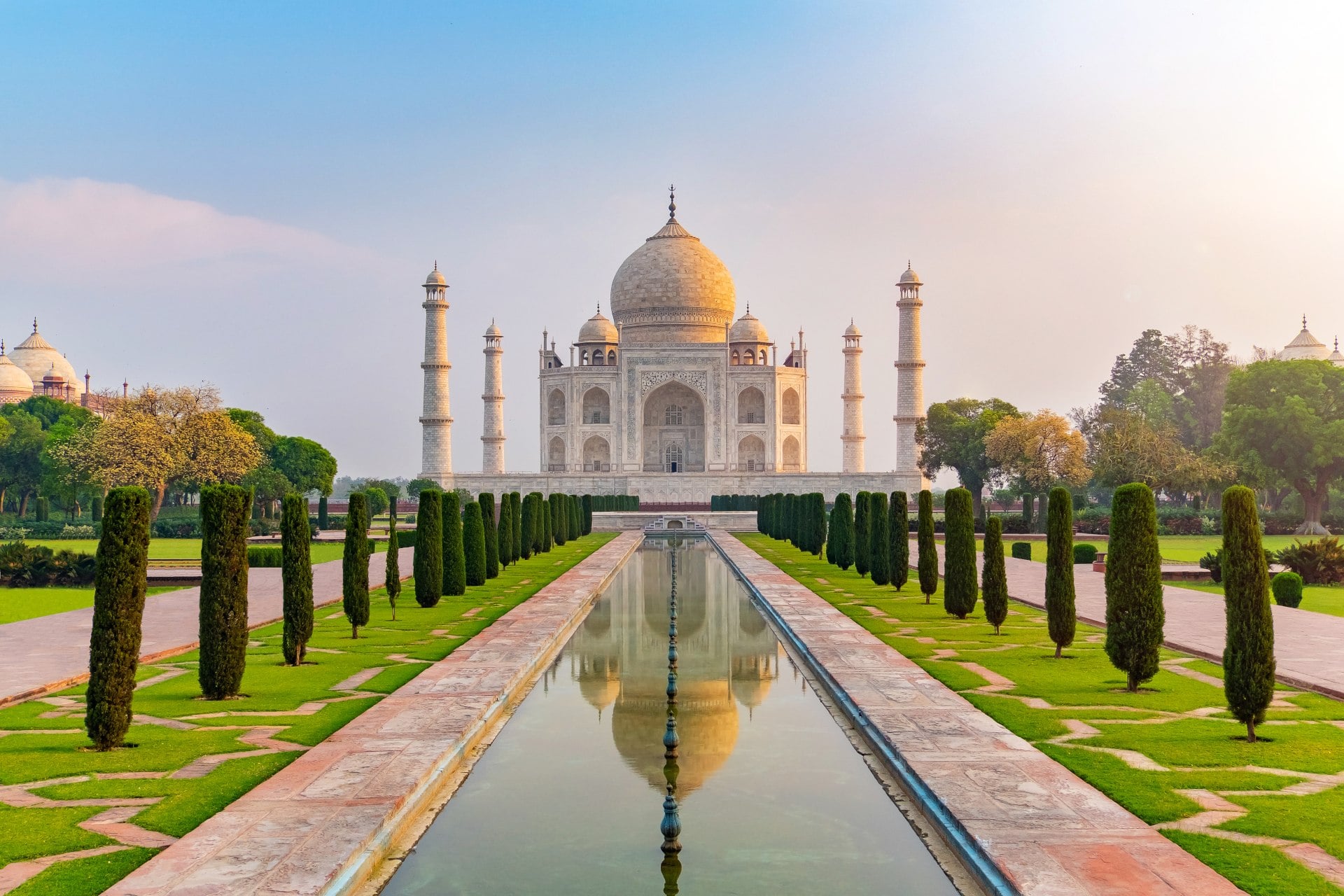 Taj Mahal front view reflected on the reflection pool, an ivory-white marble mausoleum Agra, Uttar Pradesh, India. One of the seven wonders of the world