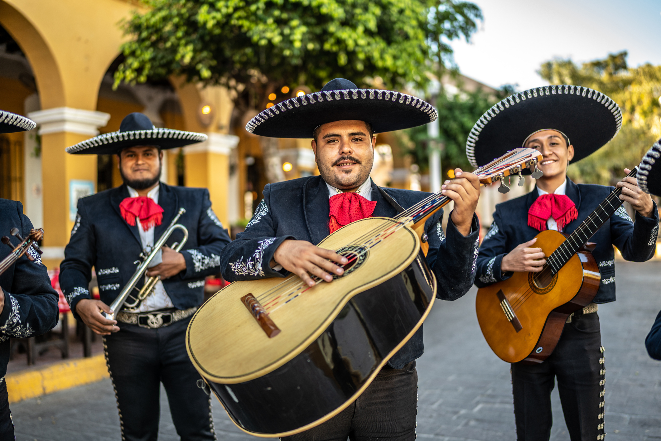Mexico City A group of Mexican mariachi musicians hold their instruments in an old town square.