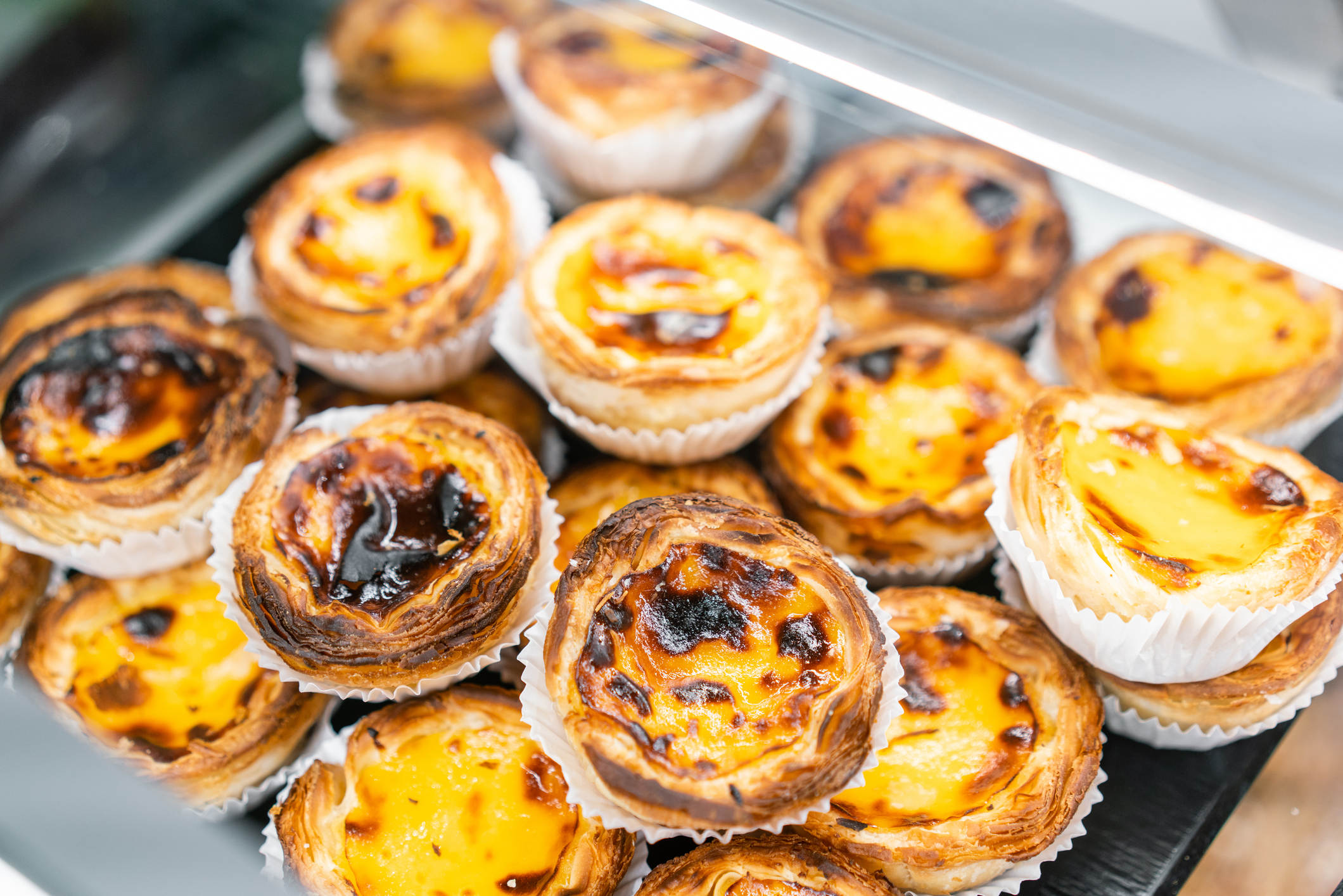 Rows of egg tarts at a bakery in Lisbon, Portugal