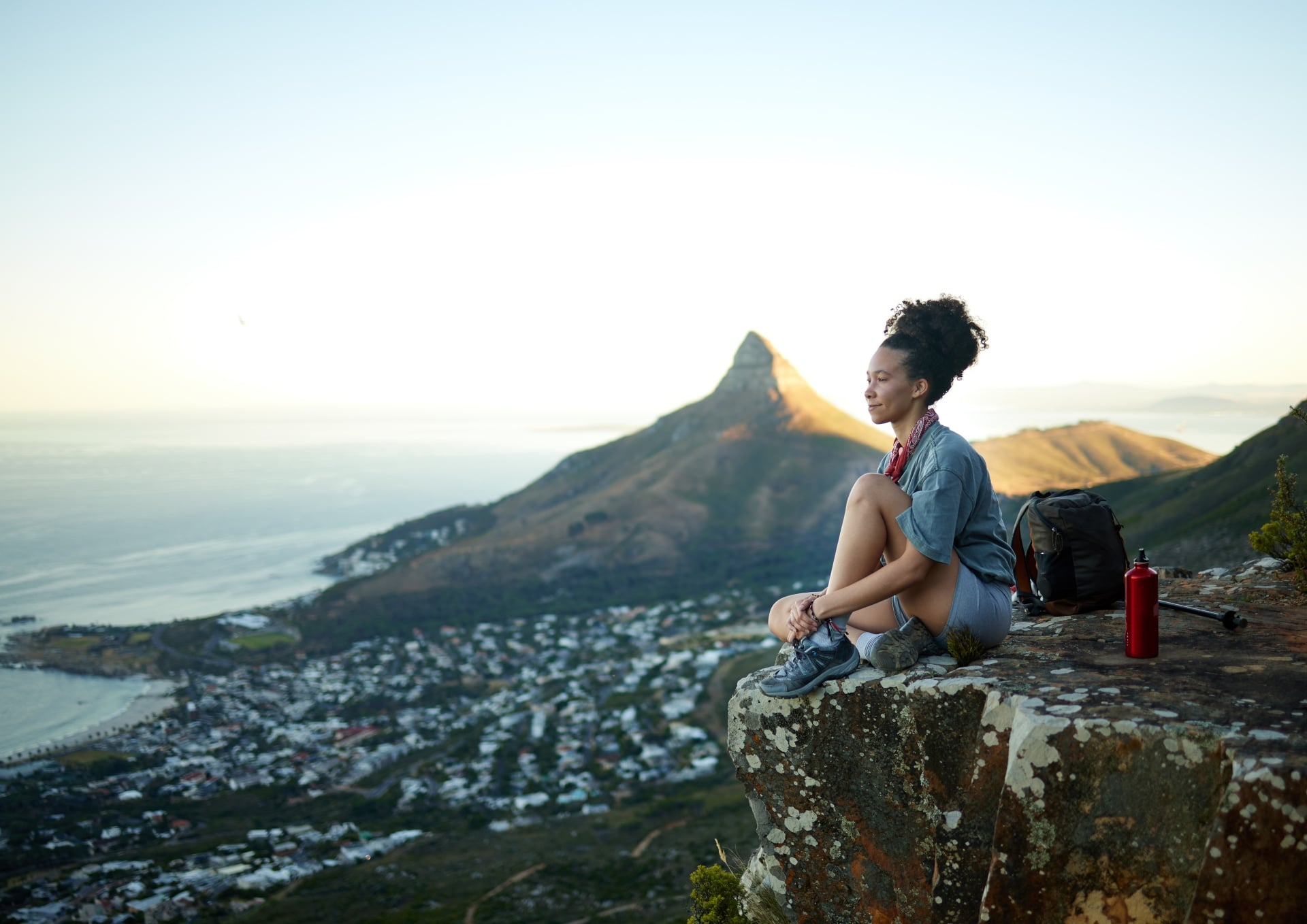 Table Mountain, Cape Town, South Africa woman on the edge of a mountain overlooking city and ocean