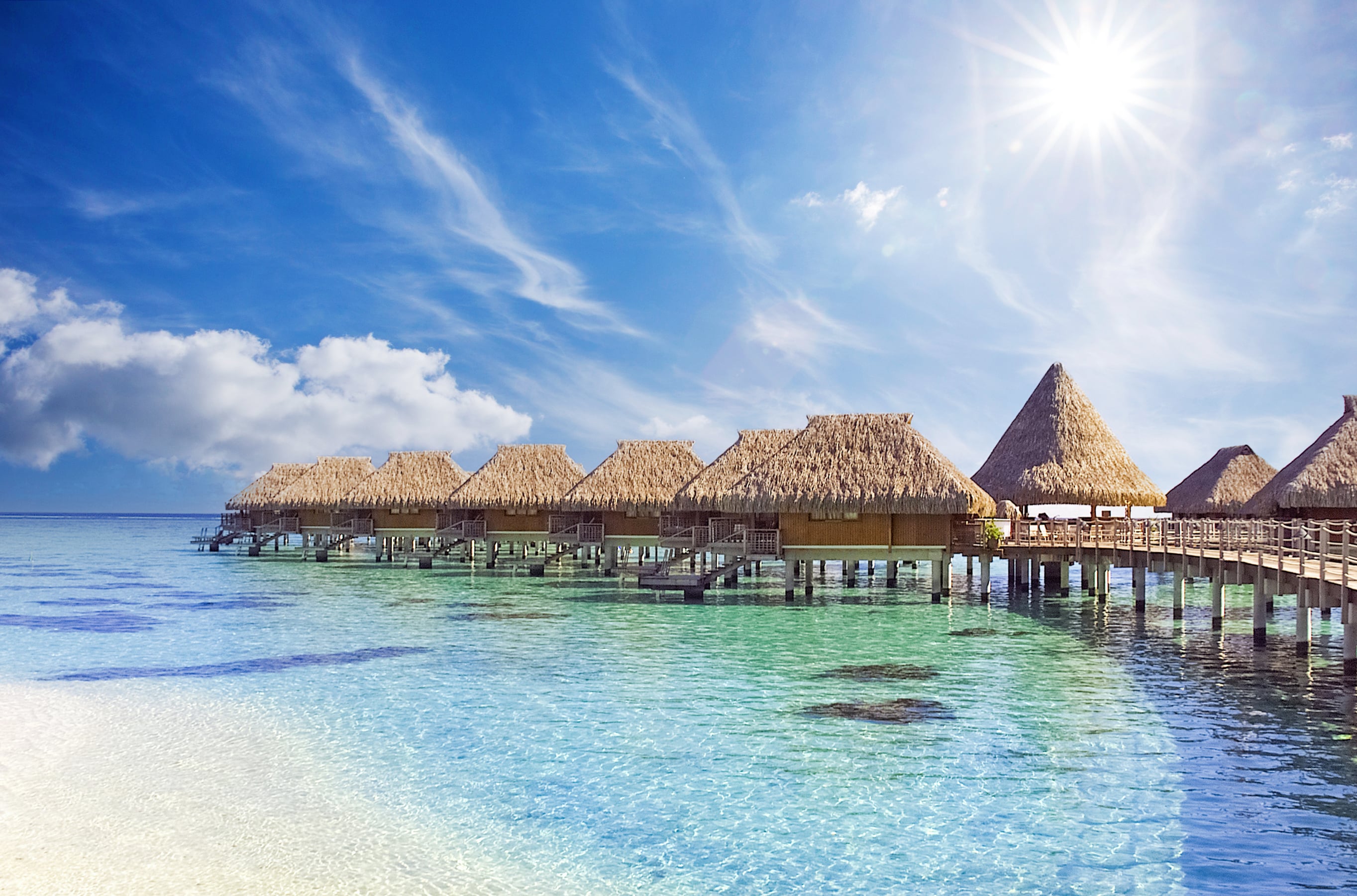 The crystal clear blue ocean waters with tropical overwater bungalows in Moorea