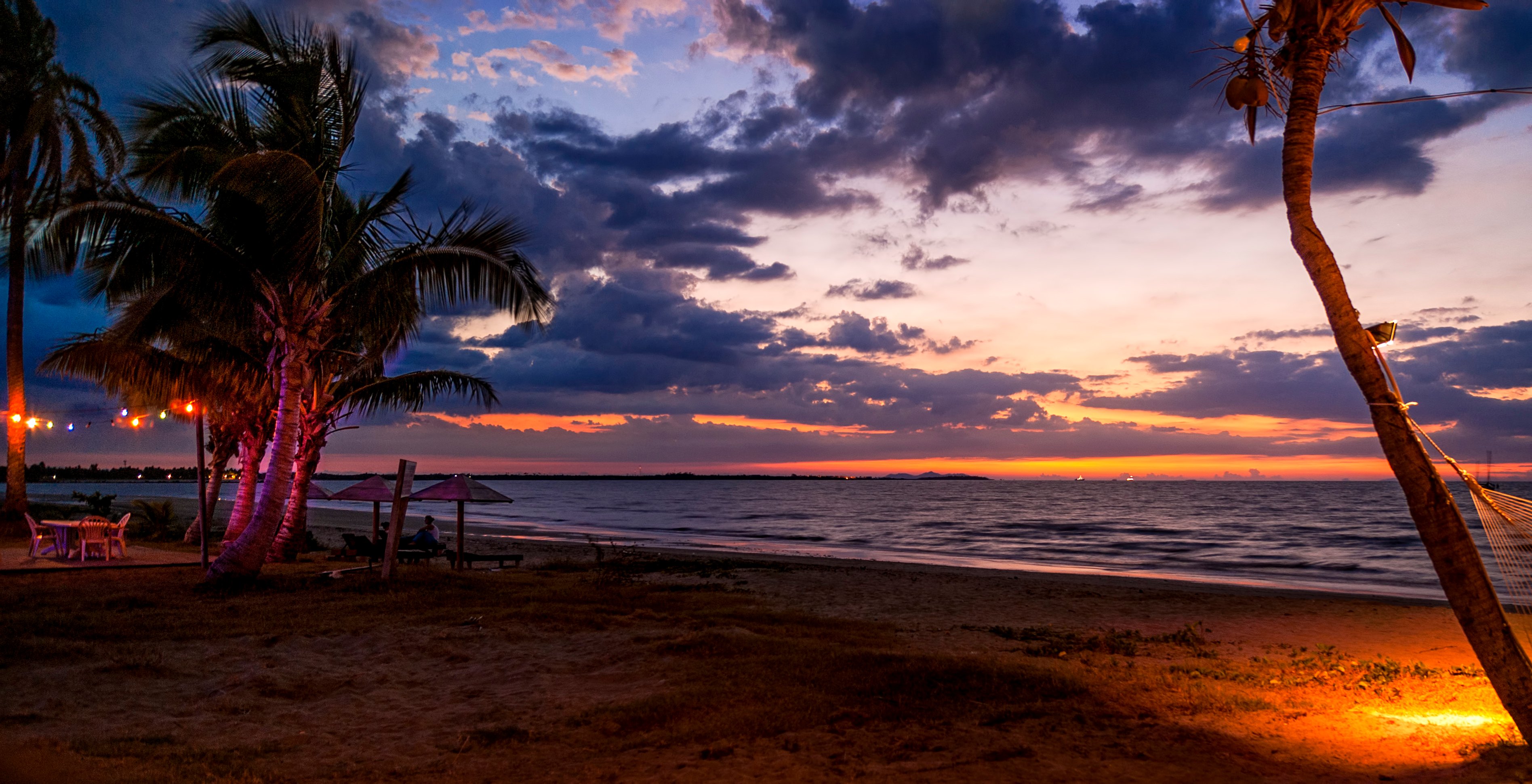 A beautiful beach setting comes to life as the sun goes down.
