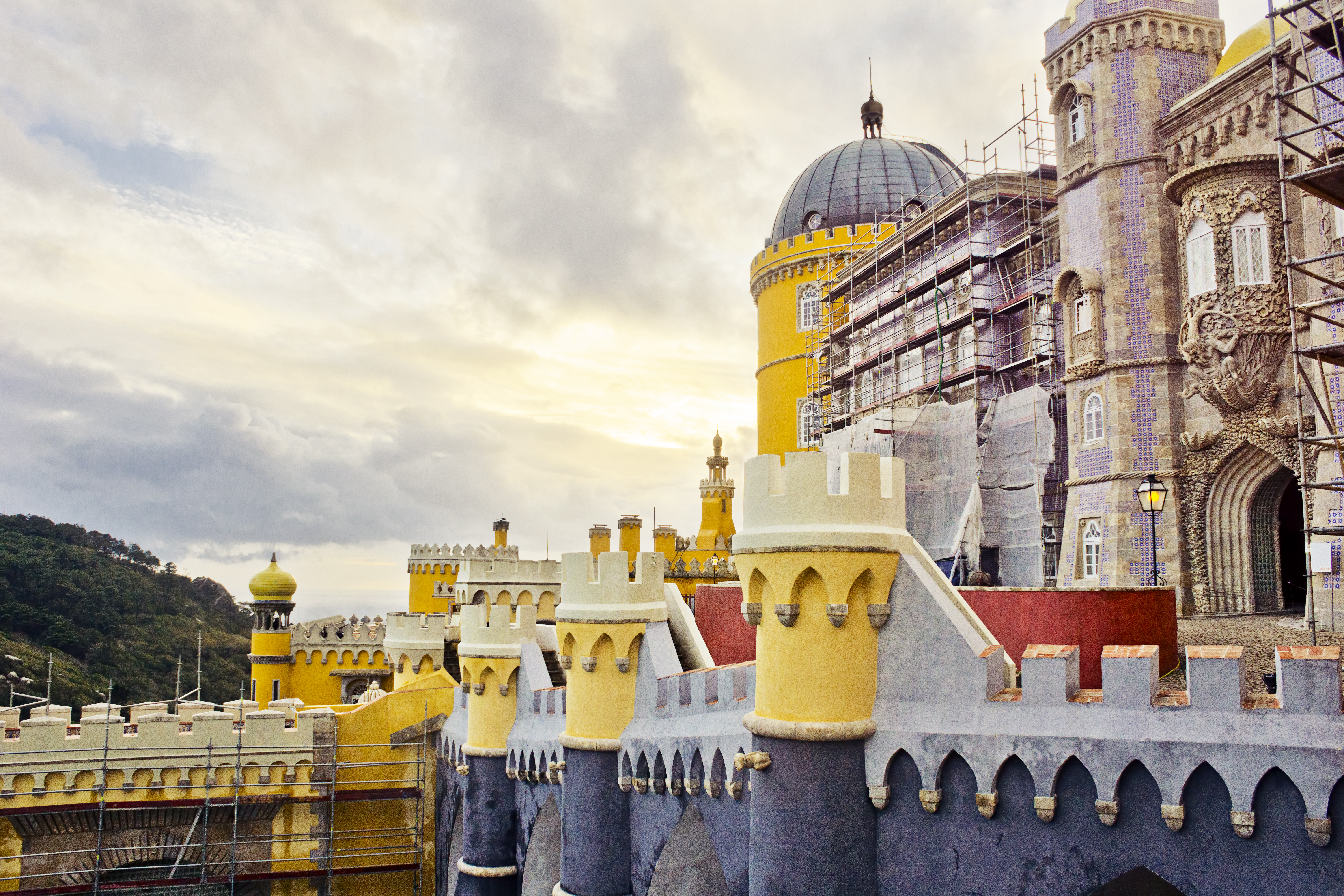 The colorful walls and towers of the Palácio Nacional da Pena in the historical Portuguese town of Sintra on a cloudy autumn day.
