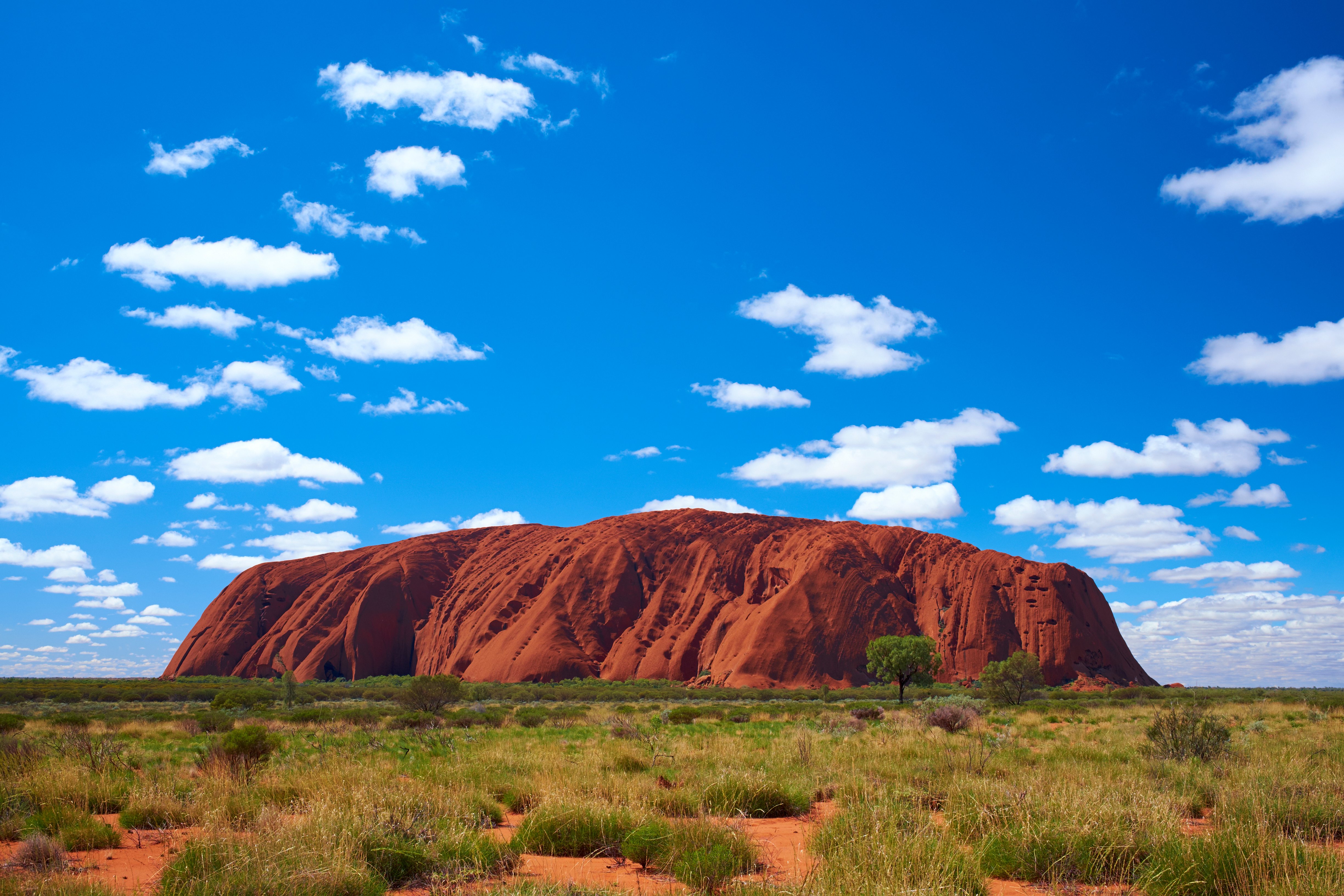 Fluffy clouds drift over Uluru (also known as Ayers Rock) in the Australian Outback. A genuine Wonder of the Natural World (and a UNESCO World Heritage Site), it's also a sacred place to the local Anangu people.