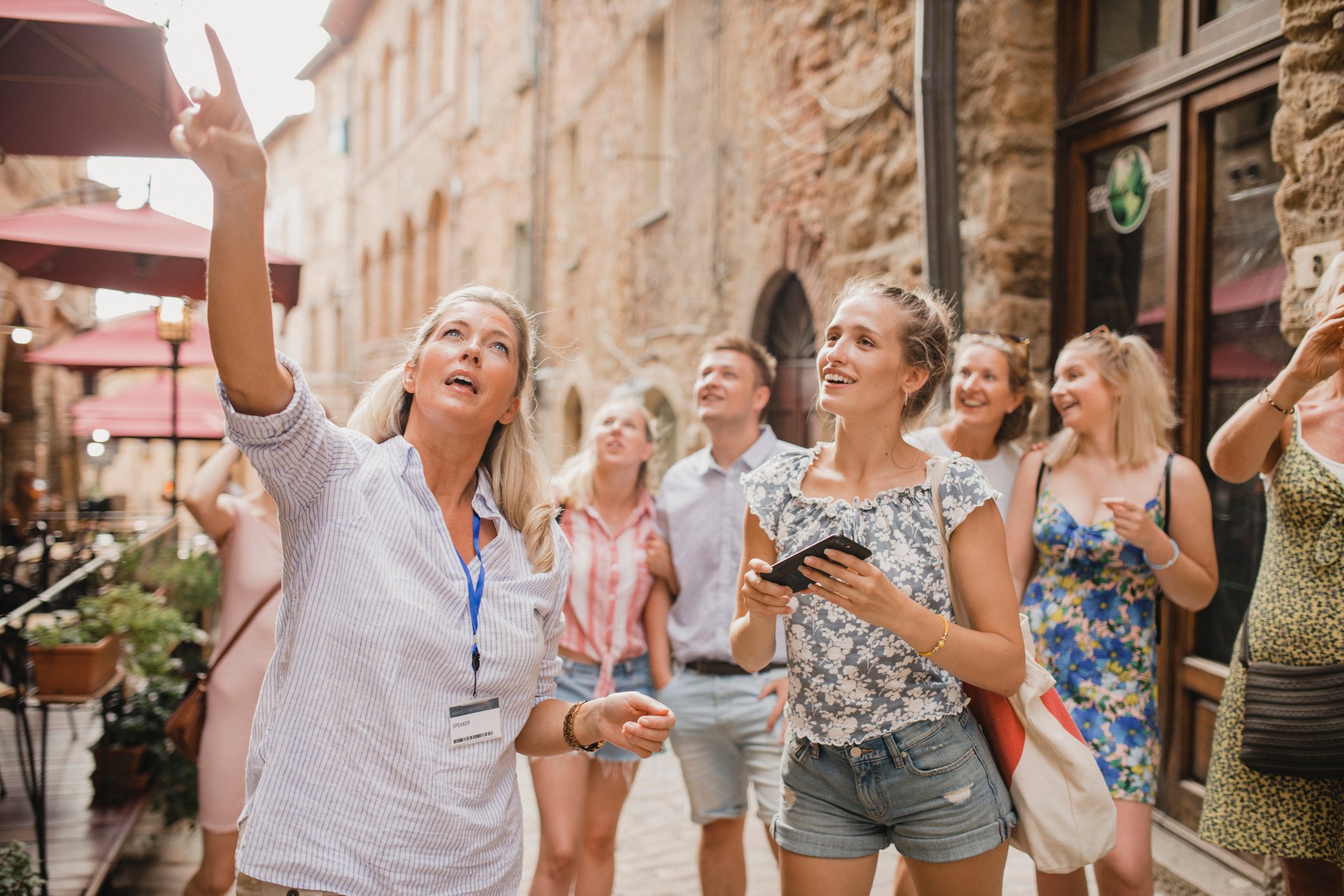 A tour guide lectures to a group of travellers in Italy.