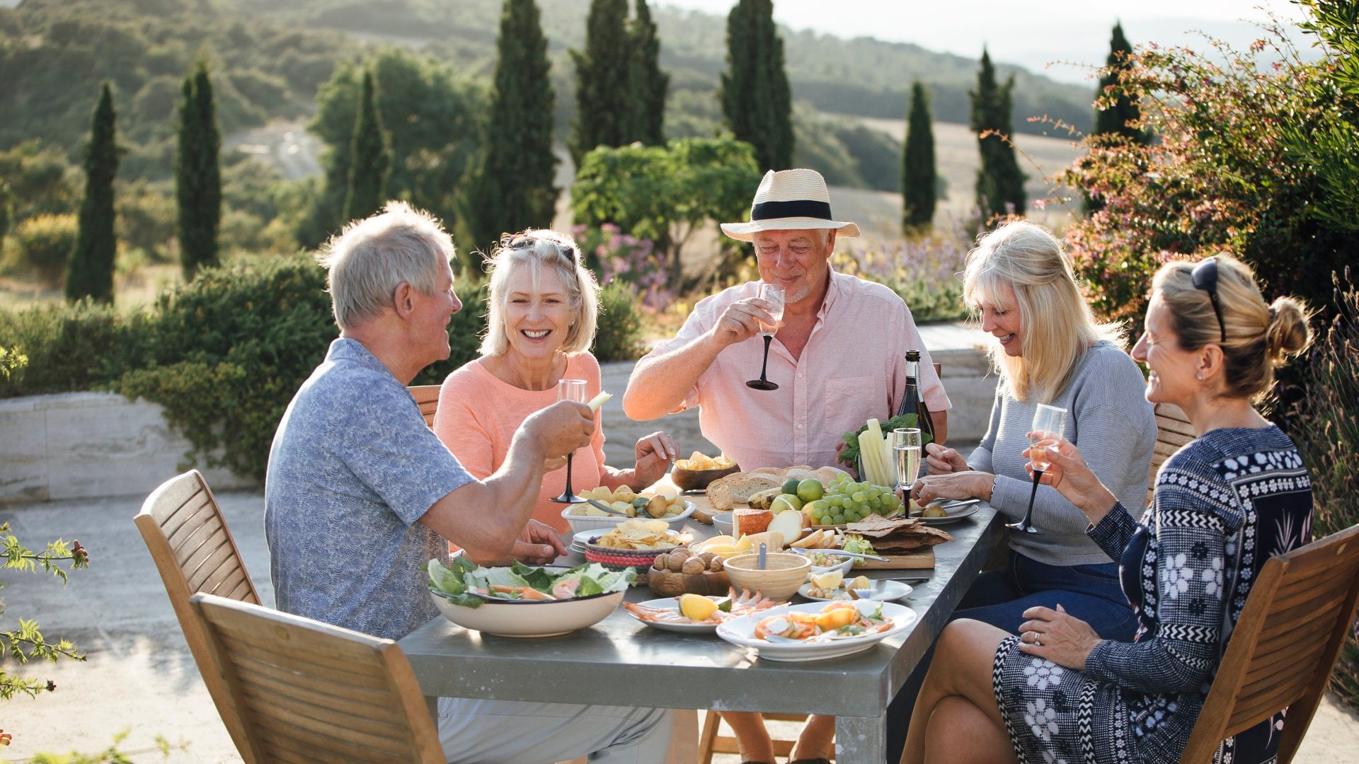 A group of people enjoy dinner around an open air table in Italy.