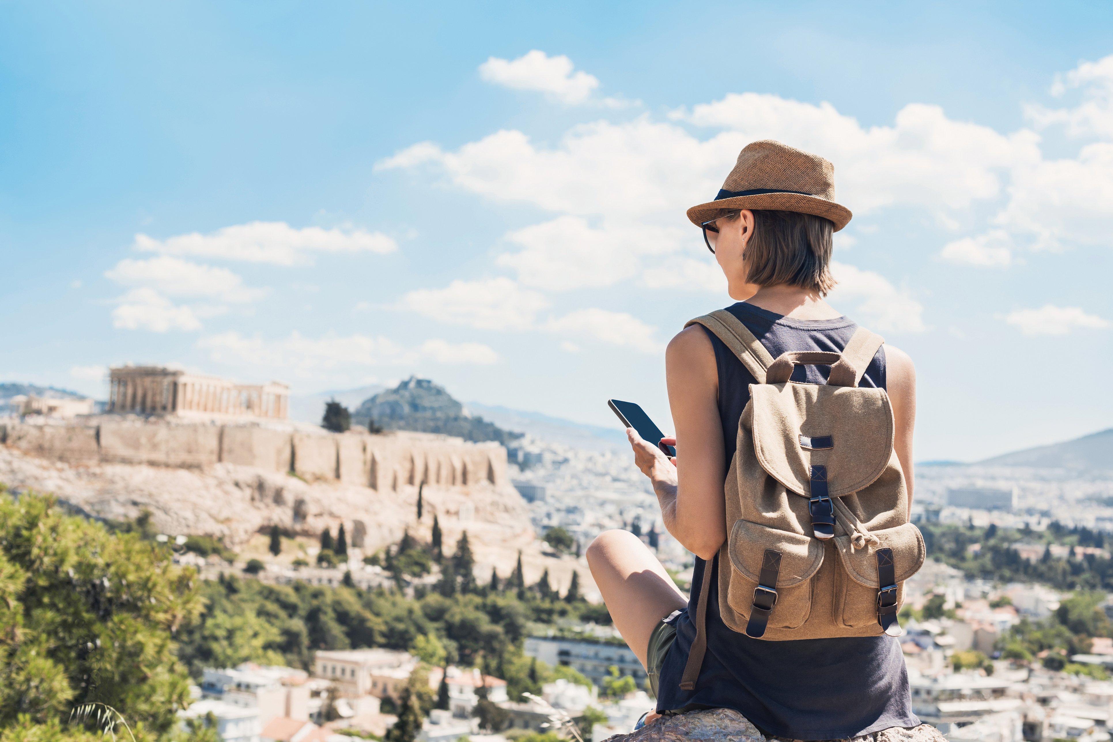 A woman checking her phone while travelling in Athens, Greece.