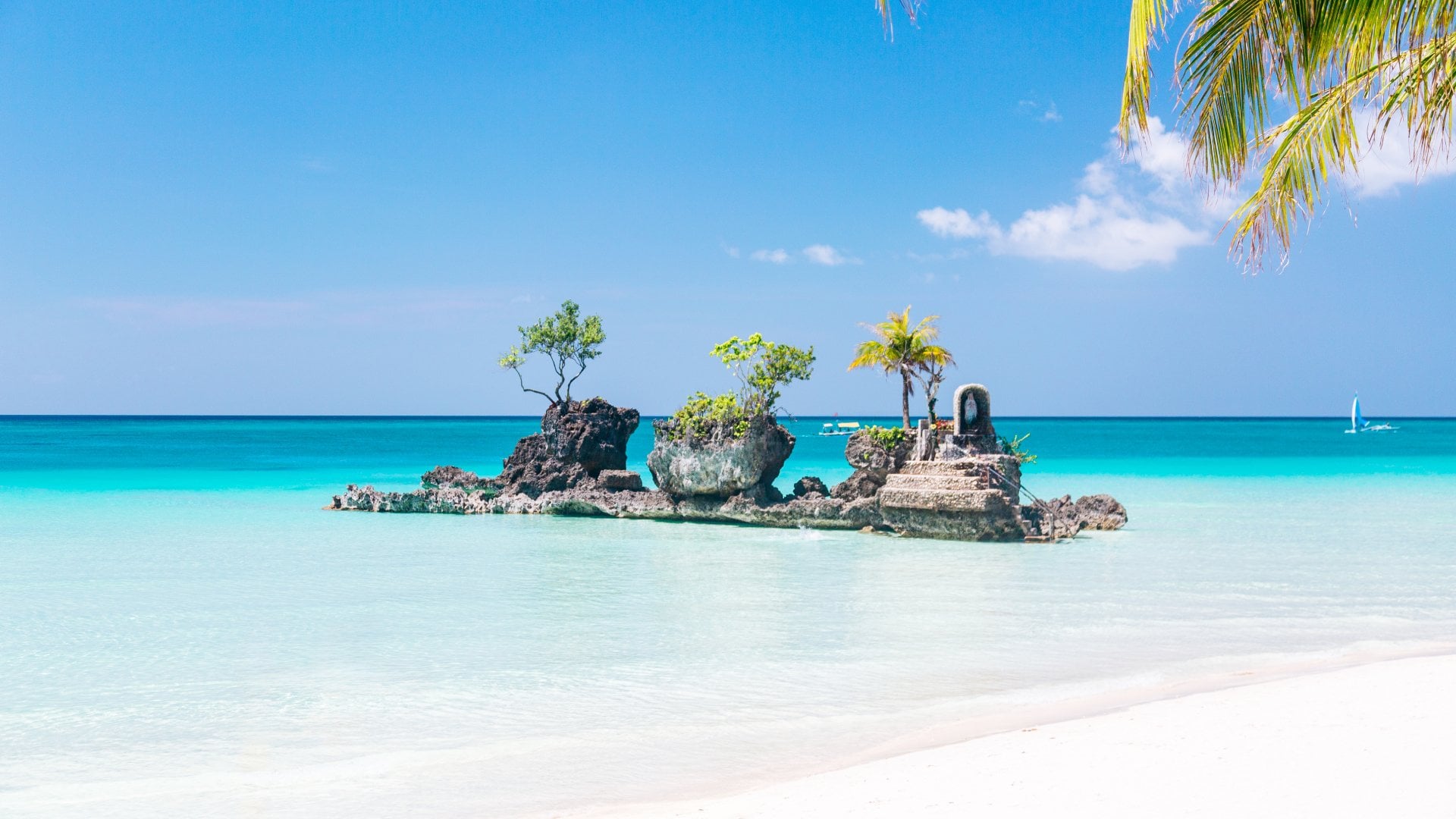  A rock formation "Willy's rock" with Palm Trees and Clear Blue Water. The White Beach - Boracay Island