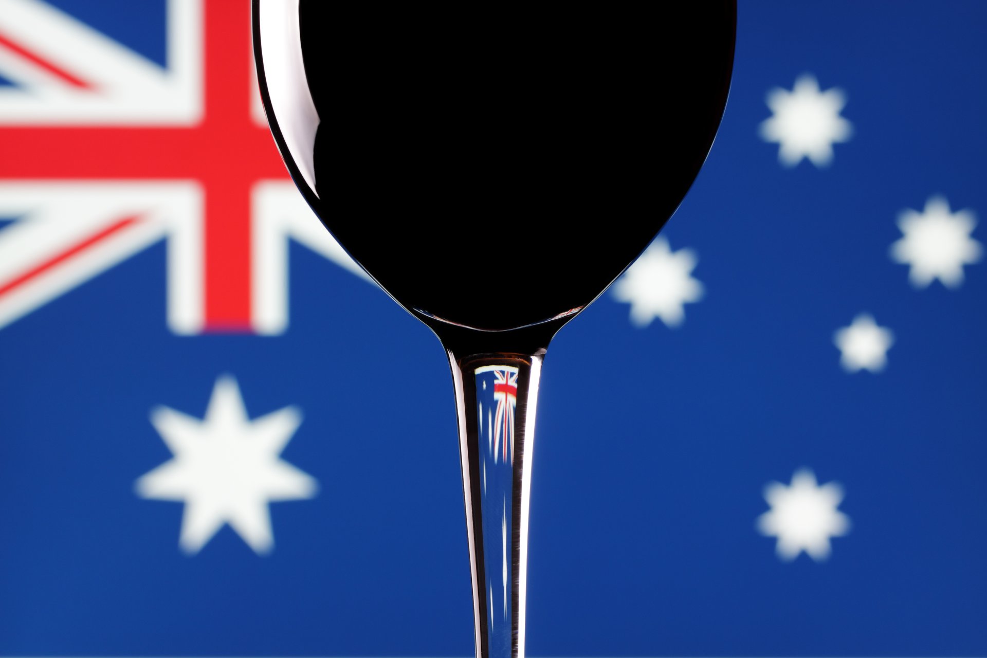 A glass of red wine, with an Australian flag background.