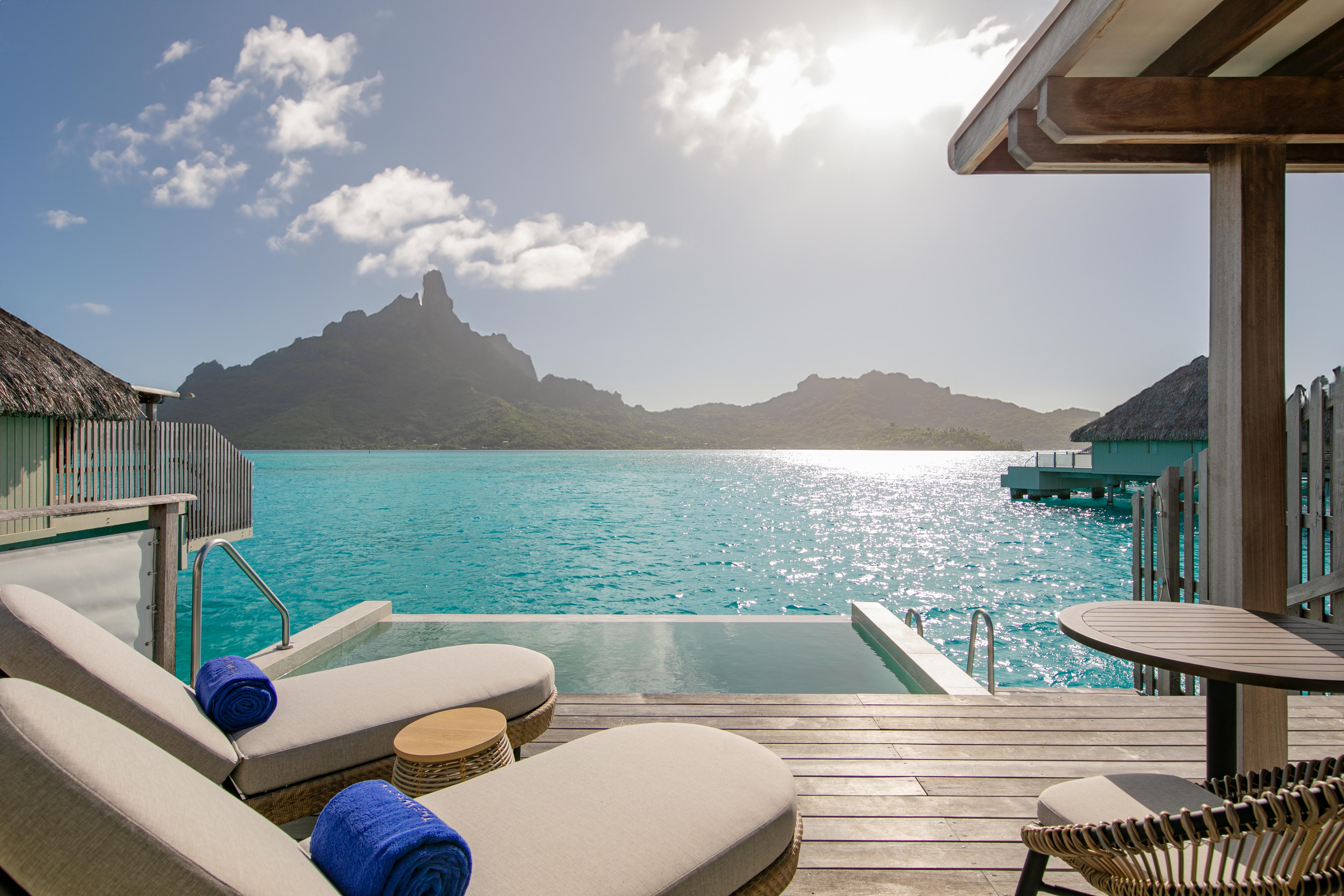 View of Tahiti's lush volcanic landscapes from the balcony of an overwater bungalow.