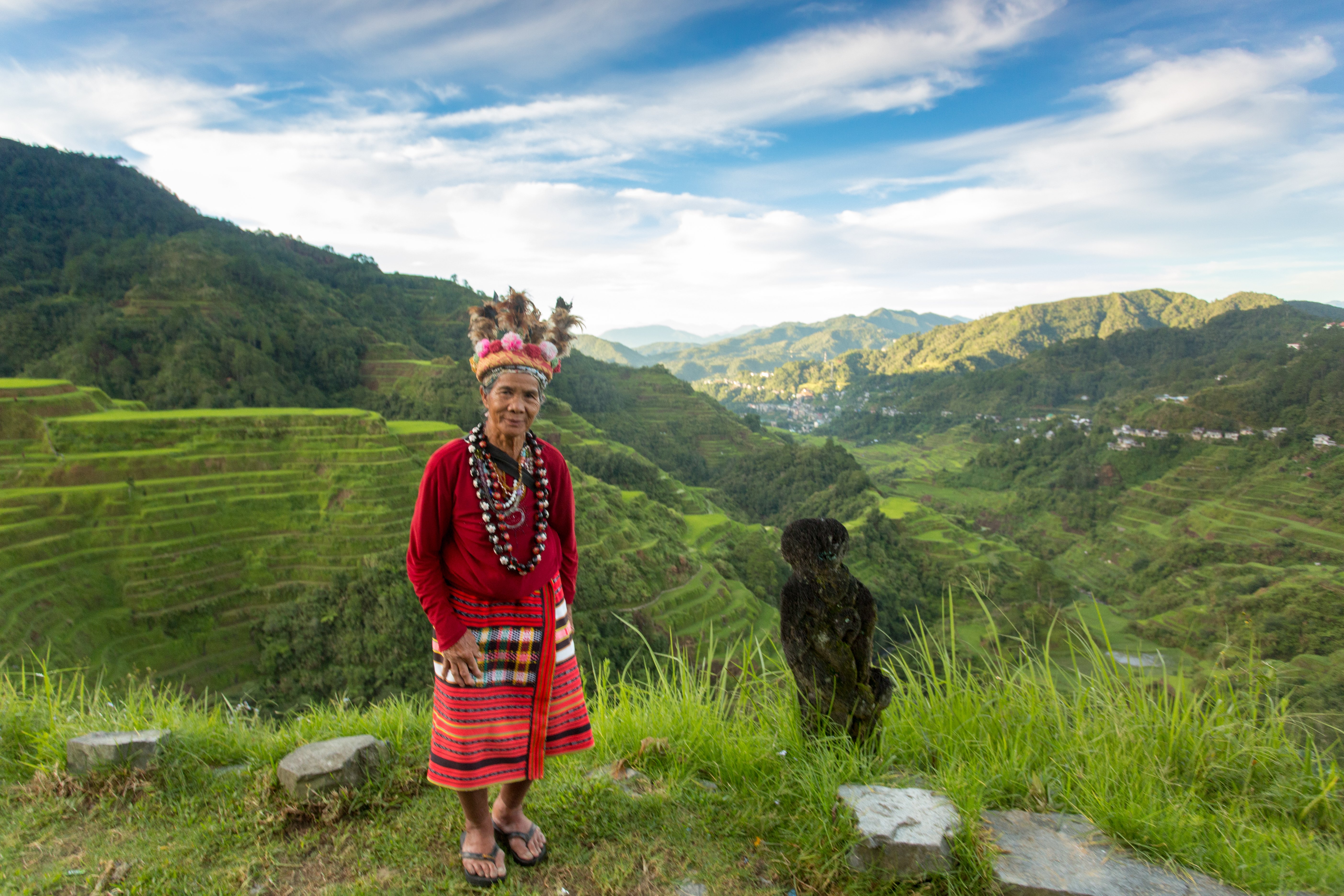 An old man in traditional Philippines atire standing atop the Banaue Rice Terraces in the Philippines.