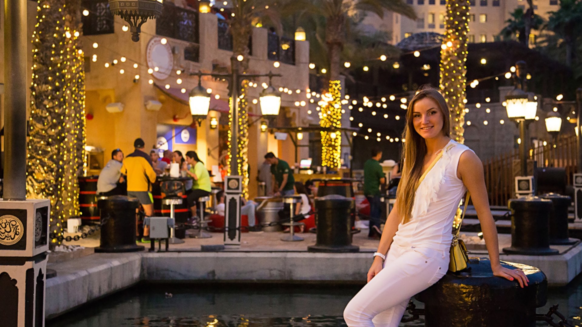Beautiful girl in white sitting in the bar in the evening time in Dubai, United Arab Emirates (UAE)
