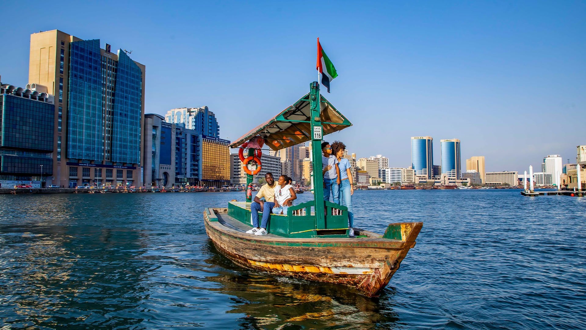 A black family goes for a ride on a traditional boat in the midst of Dubai Creek