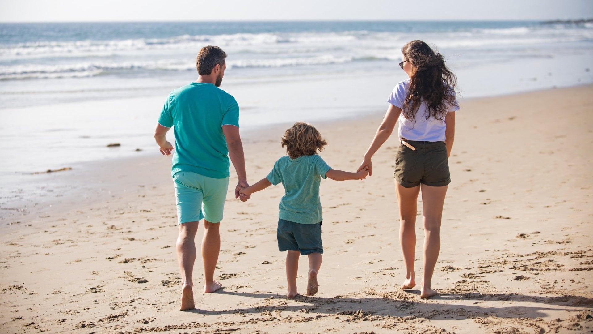 Father mother and child on the summer beach at the sunset time. Concept of friendly family. Summer holidays in Fiji.