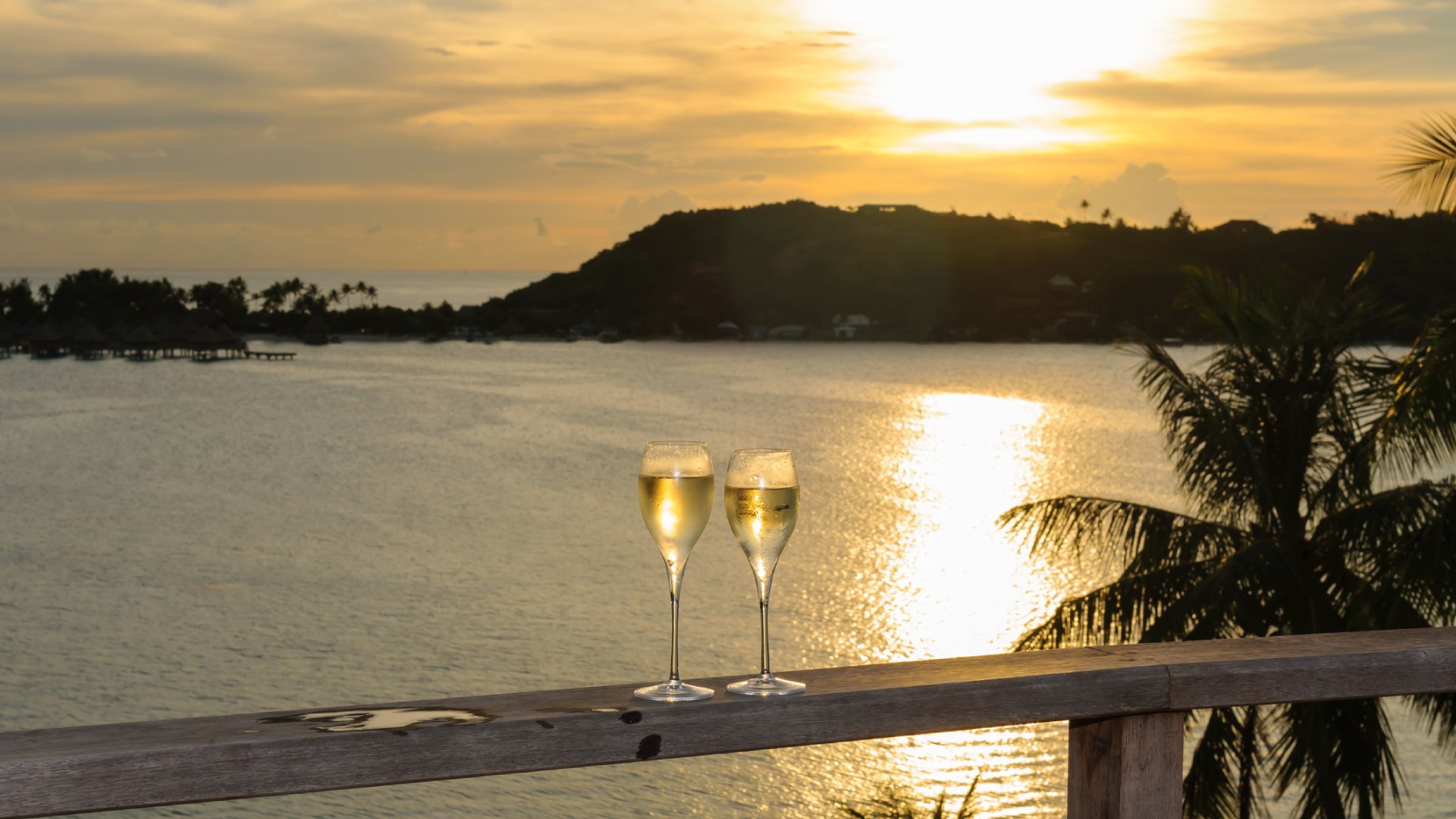 Glasses on champagne during a sunset over Bora Bora Tahiti.