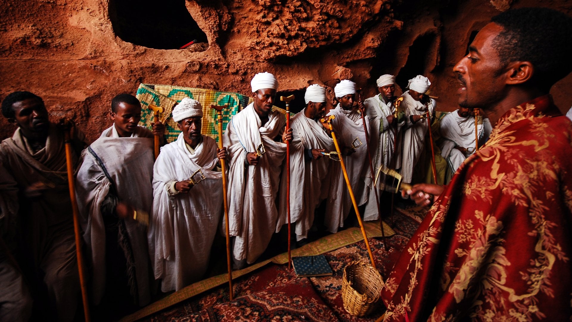 Group of priests chanting prayers inside rock hewn church