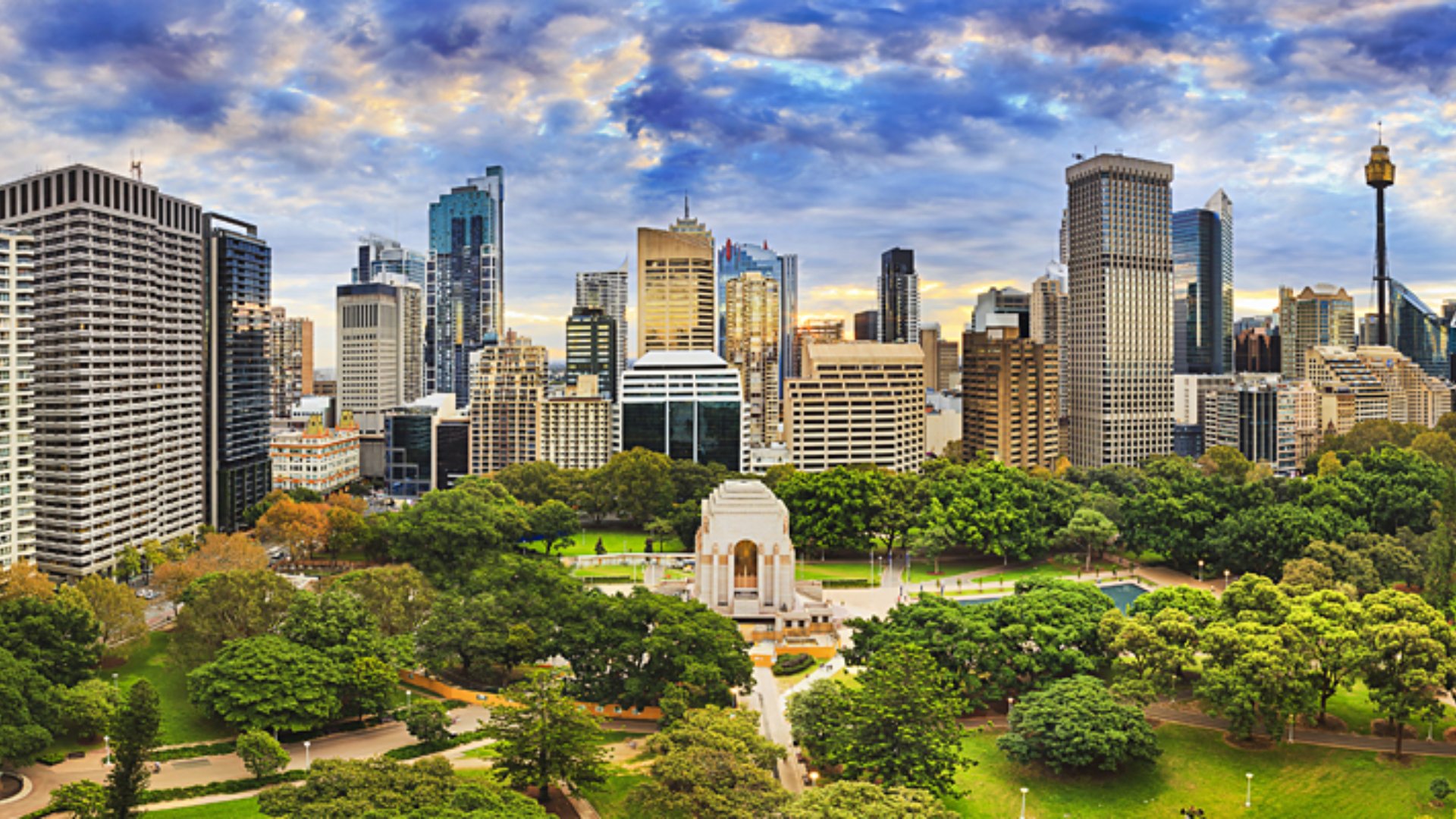 Hyde Park with ANZAC Memorial and CBD cityline on a bright autumn day, Sydney, Australia