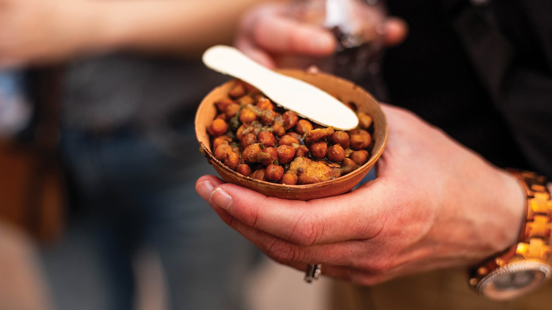 A snack of spiced chickpeas served in a small paper bowl
