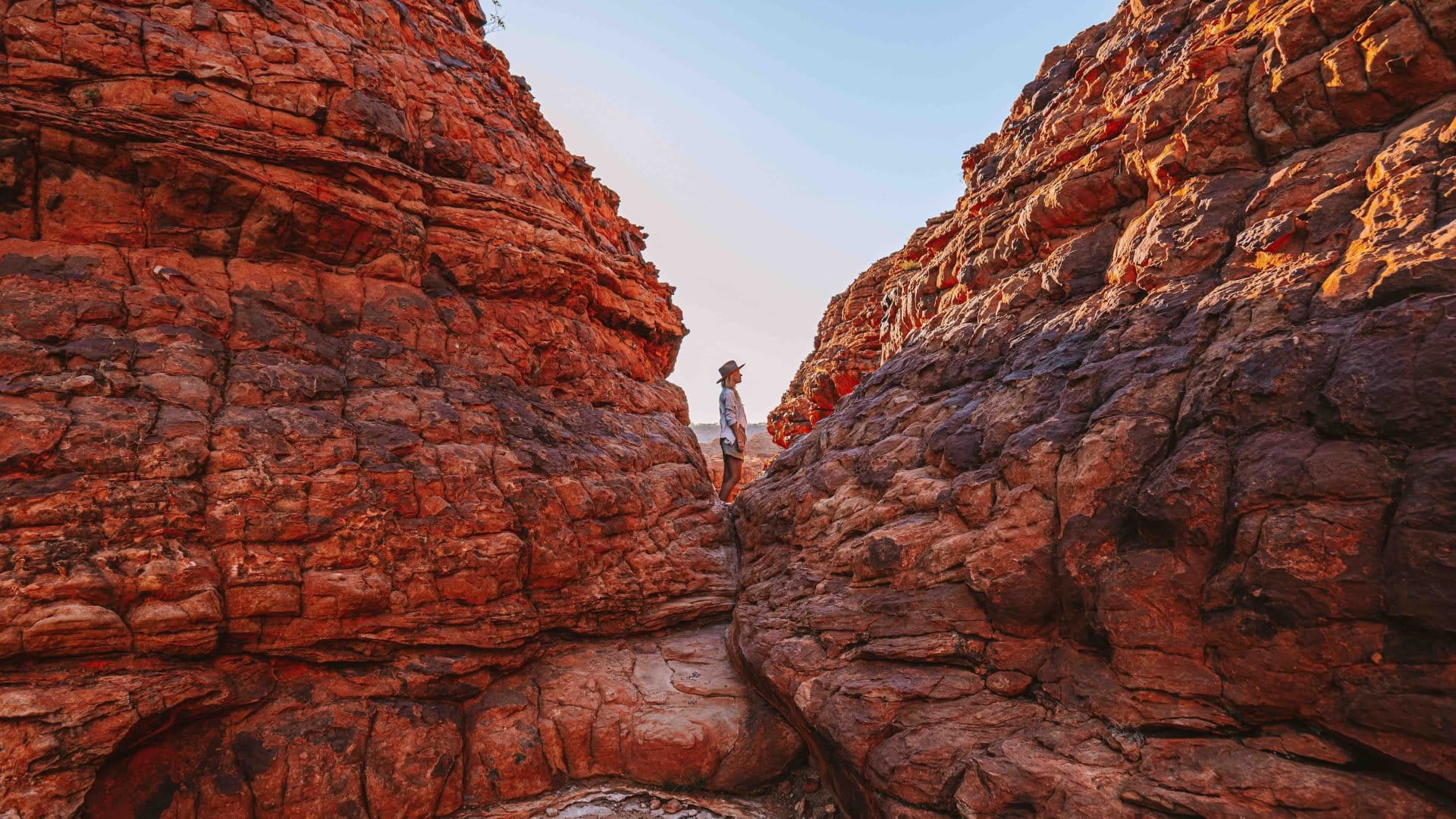 A woman standing in between a narrow pass in Kings Canyon, Northern Territory, Australia