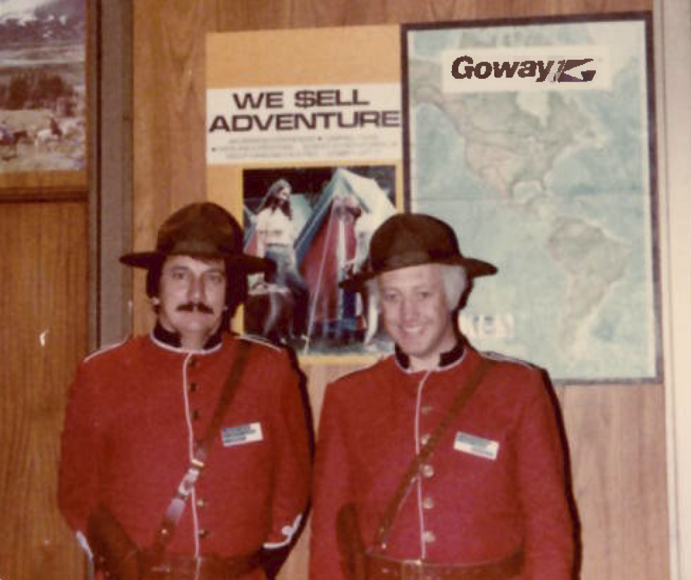 Two Goway representatives in red Mountie uniforms at a travel promotion beside Goway