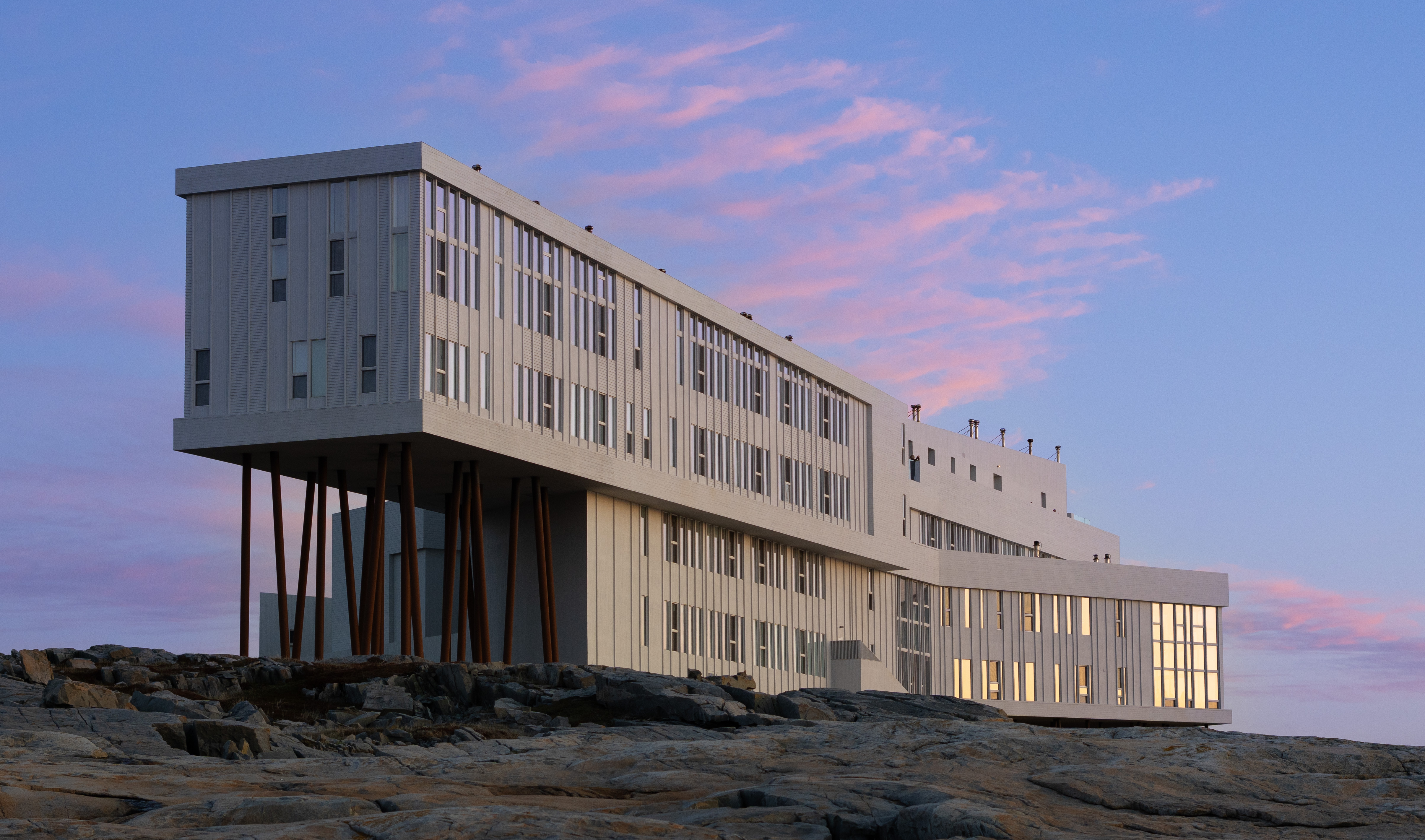 Fogo Island Inn on stilts above the rocky coastline of Fogo Island, Newfoundland and Labrador, at sunset