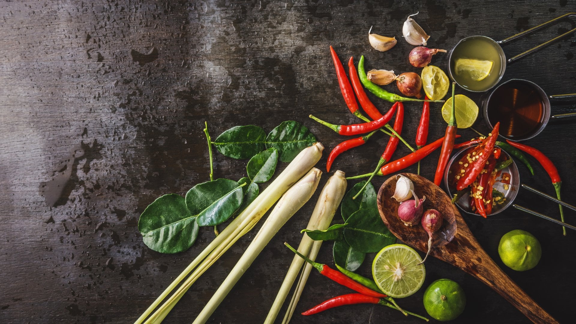 Spices for use as cooking ingredients on a wooden background with Fresh vegetables.