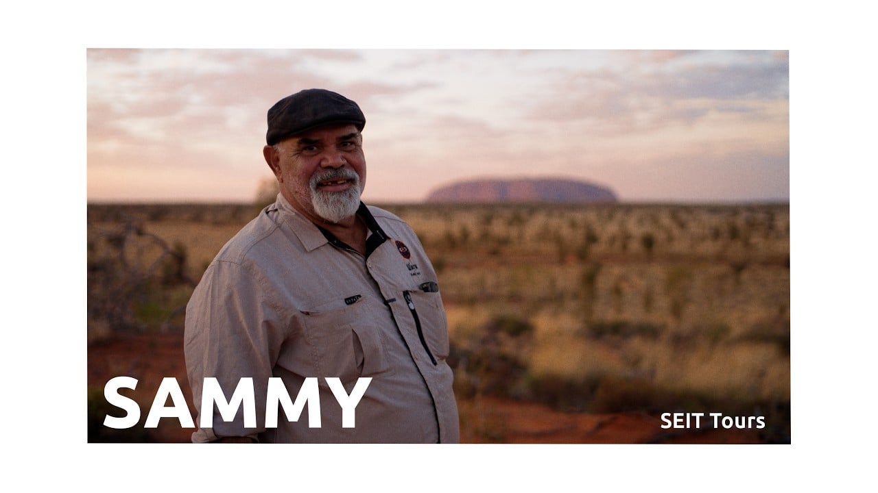 Sammy of SEIT Tours standing in front of Uluru in the Northern Territory, Australia.