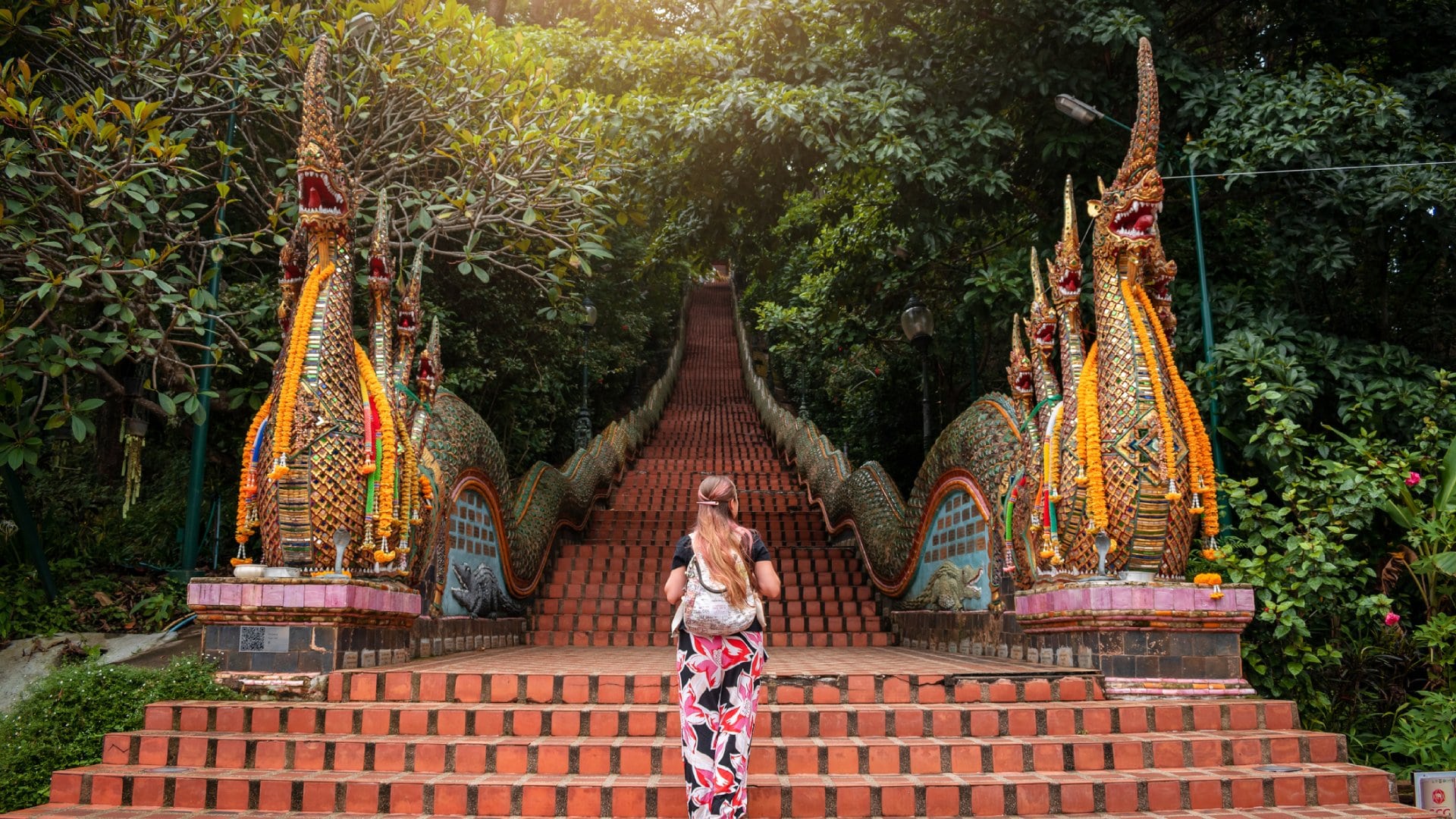 Young woman walking up the stairs of the temple, Doi Suthep in Chiang Mai, Thailand