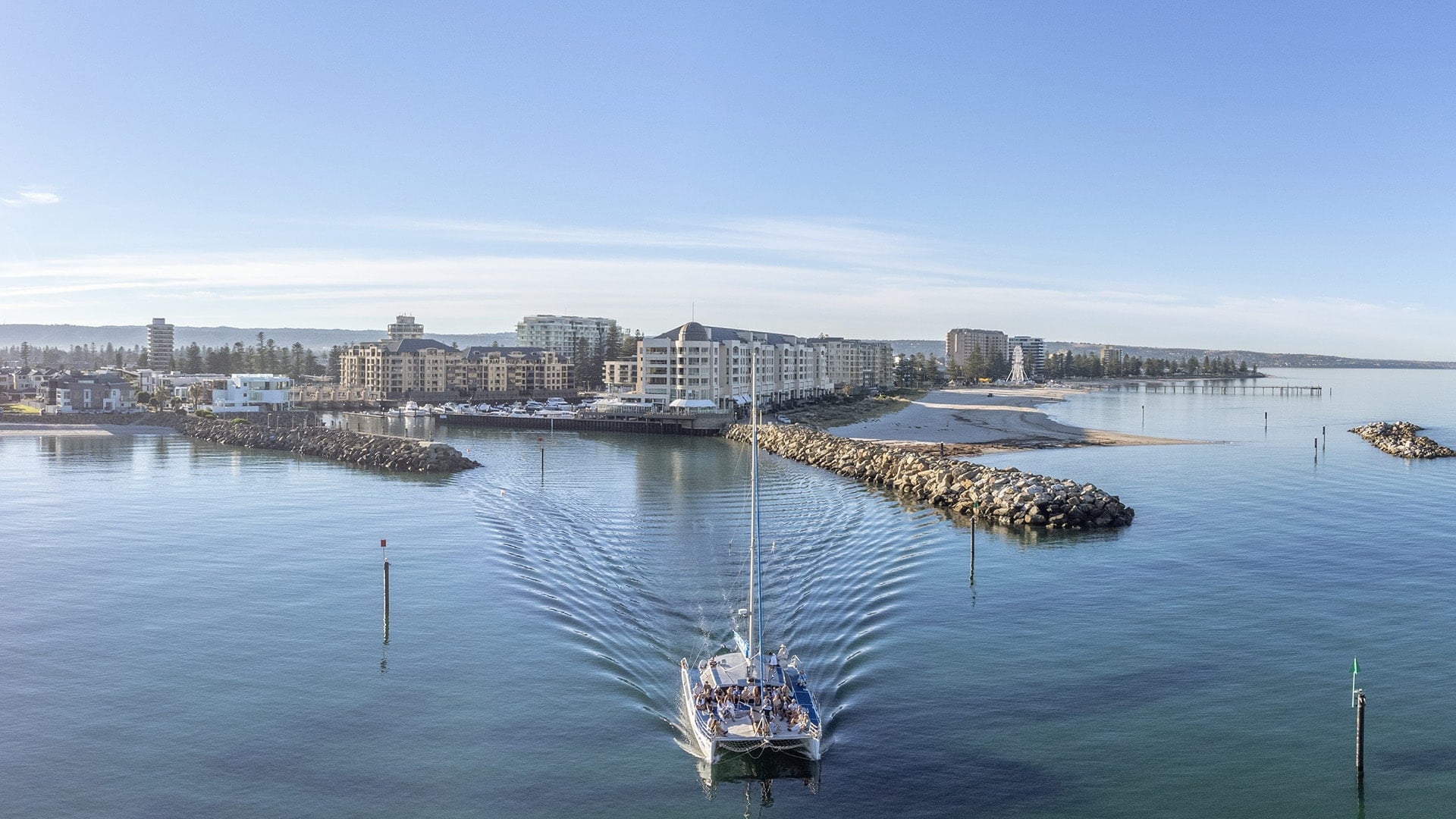 A sailboat full of people leaving a port in Adelaide