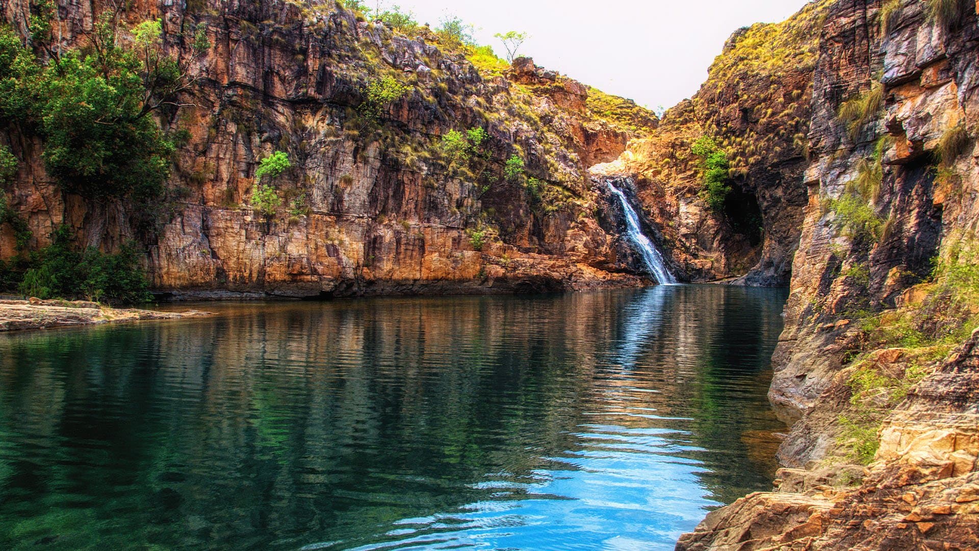 trickling water and small waterfall in the red landscape of Barramundi Gorge of Kakadu National Park in Australia